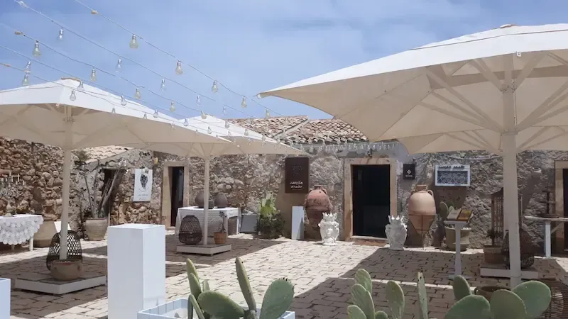 Outdoor seating area in Marzamemi with umbrellas and rustic Sicilian décor