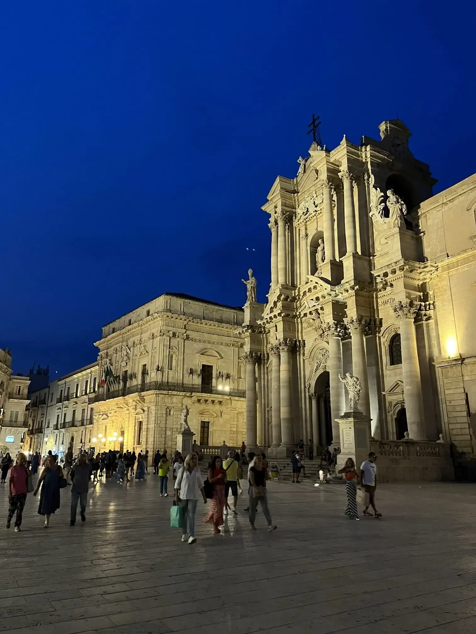 Ortigia Cathedral Square at sunset with baroque architecture and travelers exploring Siracusa.