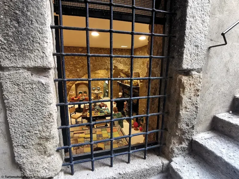Close‑up of a window with Sicilian ceramic items displayed inside in Caltagirone