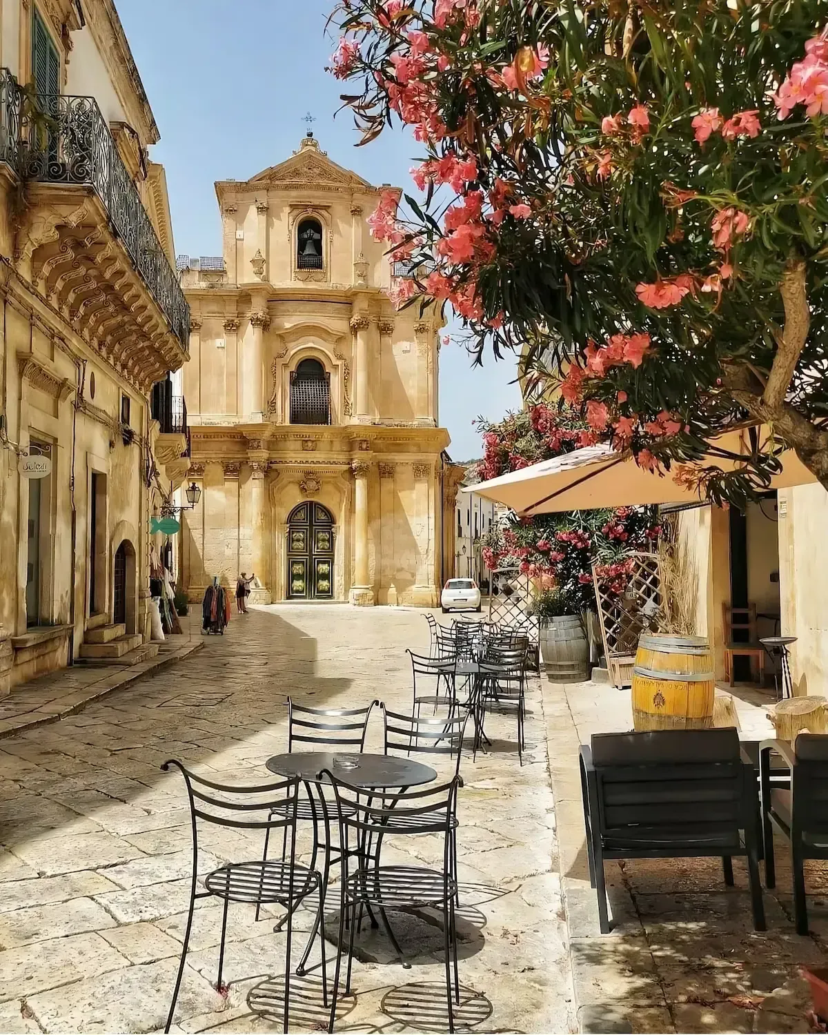 Baroque church in Scicli with flowering trees in the foreground