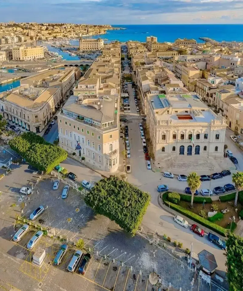 Aerial view of Siracusa with coastline, historic buildings and blue sea