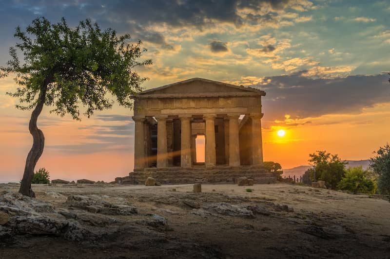 Temple of Concordia in Agrigento at sunset with a tree in the foreground