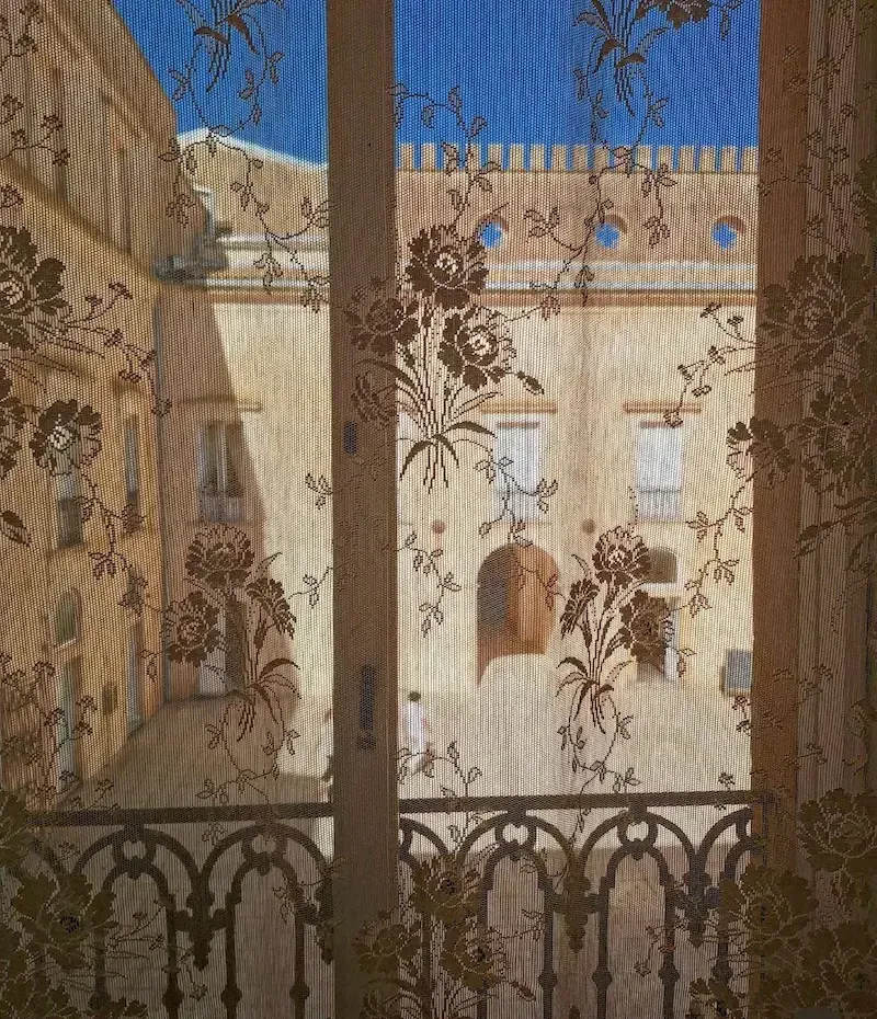 Donnafugata Castle seen through decorative curtains with detailed stone architecture