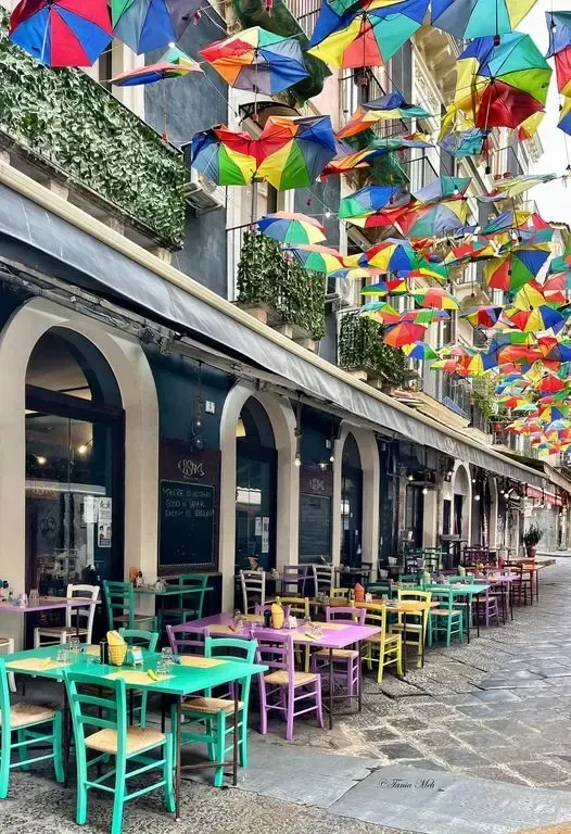 Colorful umbrella‑decorated street in Catania’s historic center
