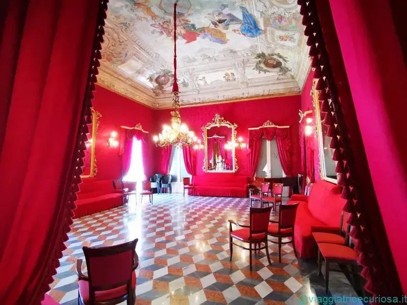 Elegant interior of the Circolo di Conversazione in Ragusa with chandeliers and red walls
