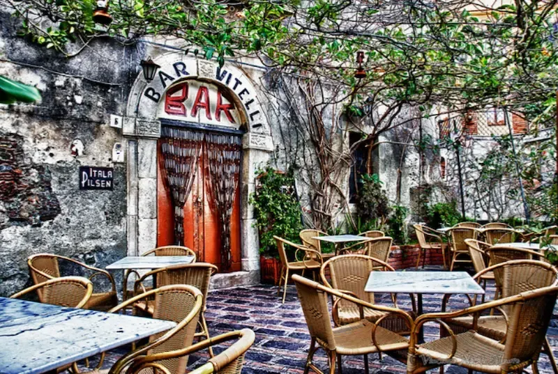 Outdoor café in Savoca with stone walls and tables, iconic filming location from The Godfather