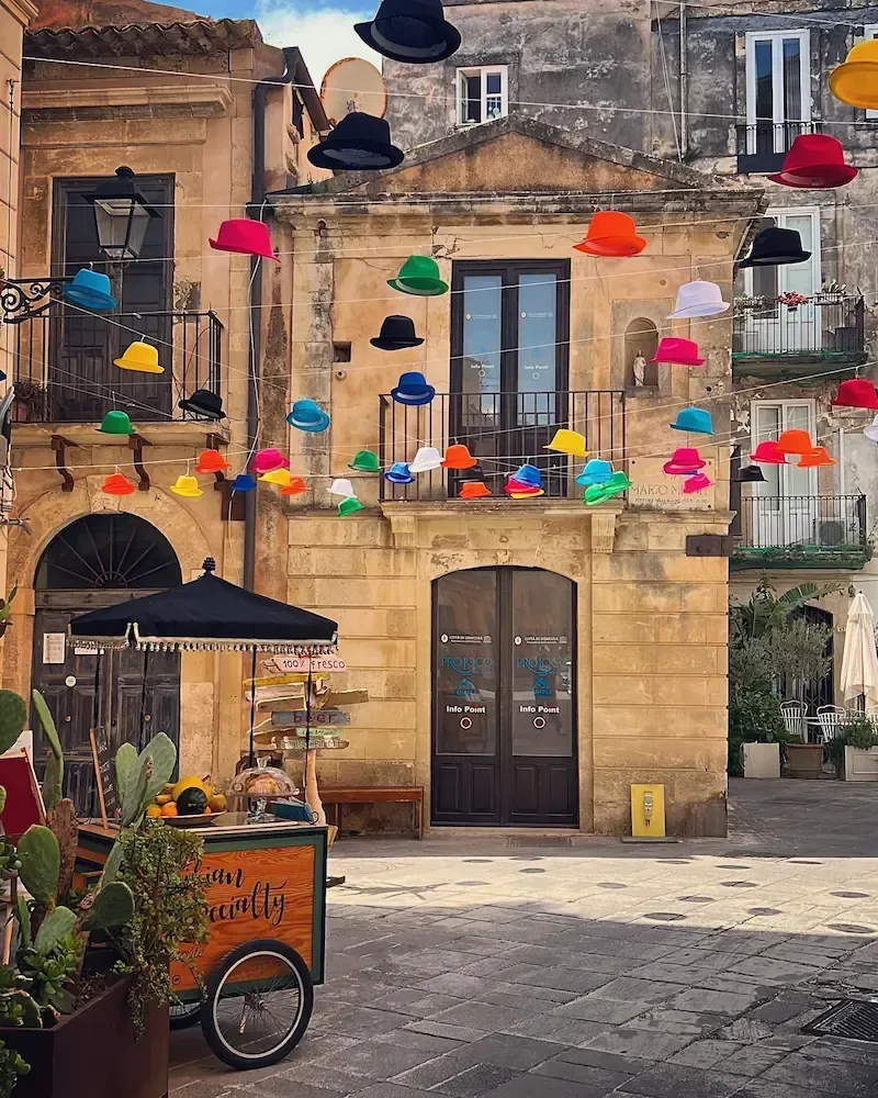 Colorful umbrella‑decorated street in Ortigia, Siracusa