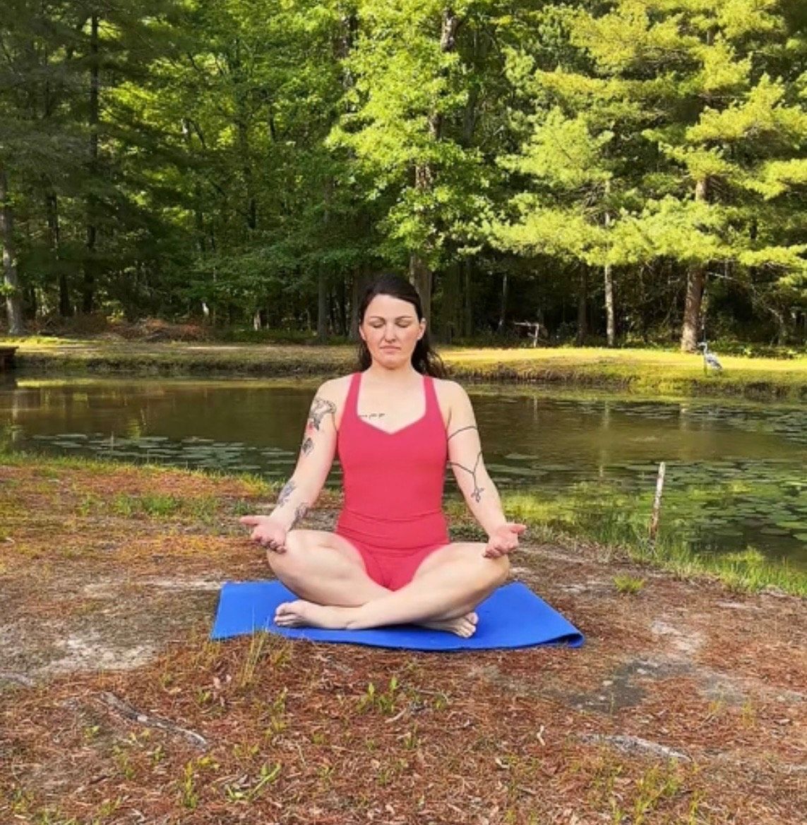 A woman wearing glasses and a black shirt that says why yoga