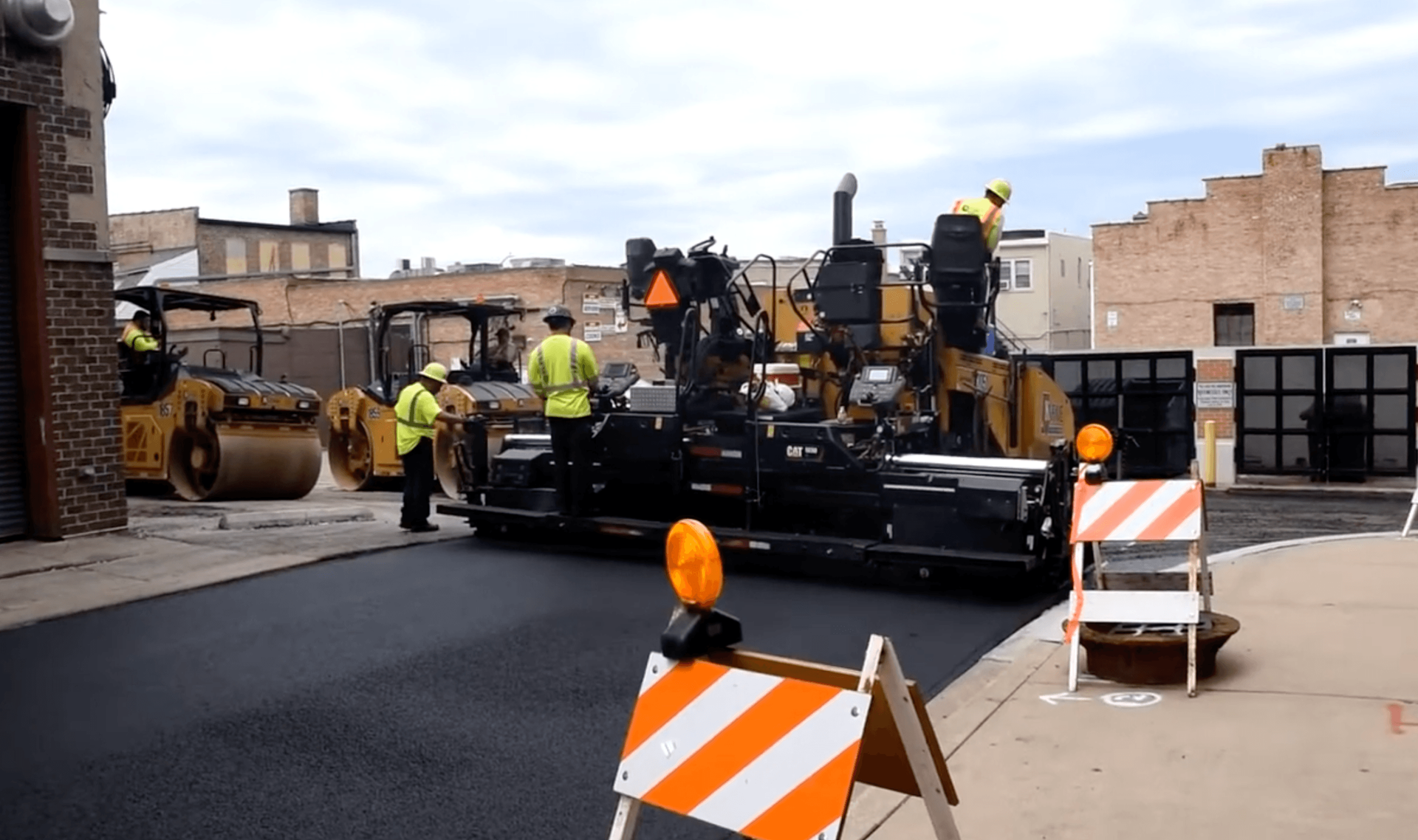 Yellow paving machine applying a smooth new layer of asphalt along a highway with scenic surroundings during an asphalt paving service in Centennial, CO