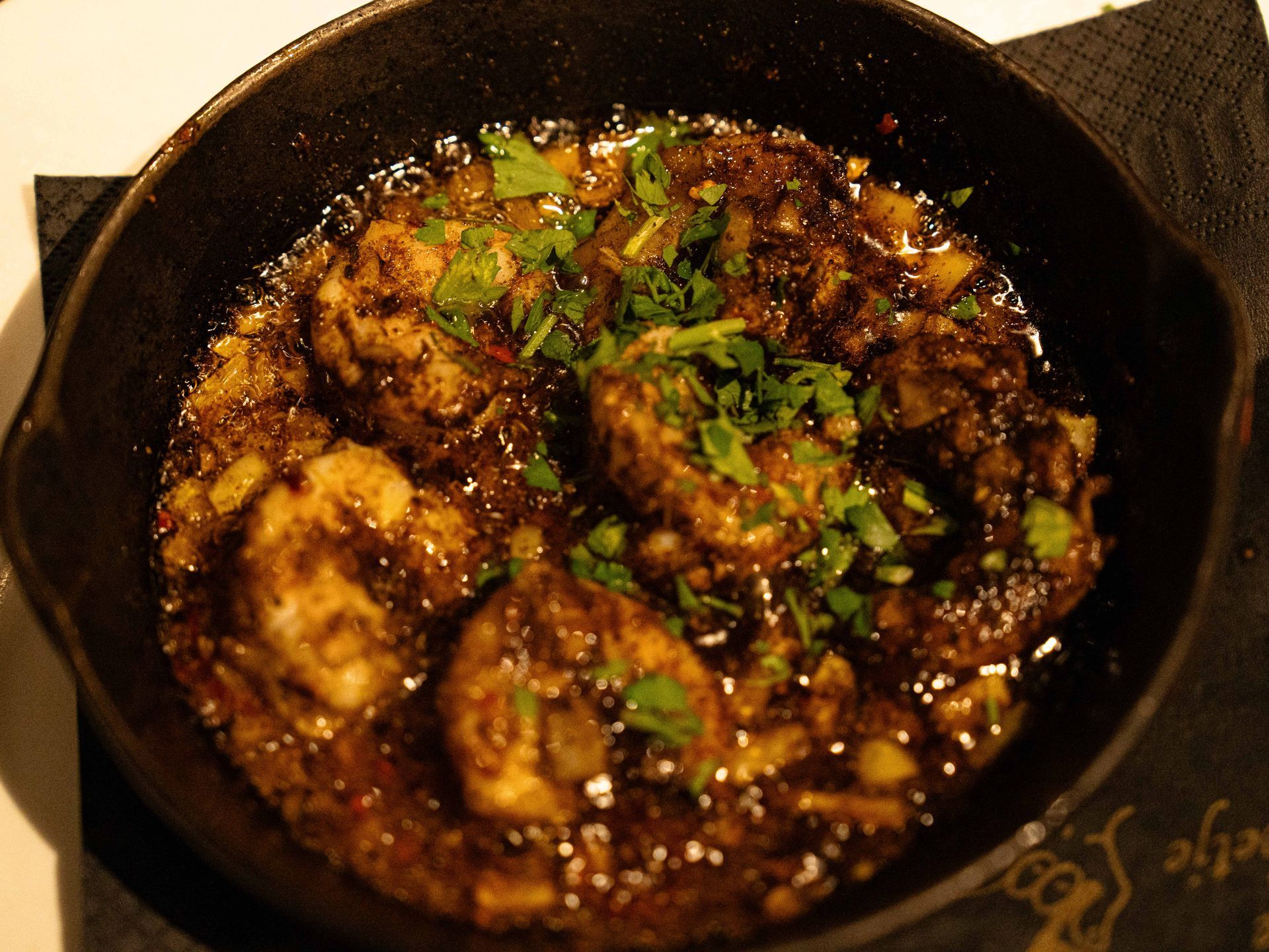 Een gietijzeren koekenpan gevuld met vlees en saus.. Bij Linke Loetje