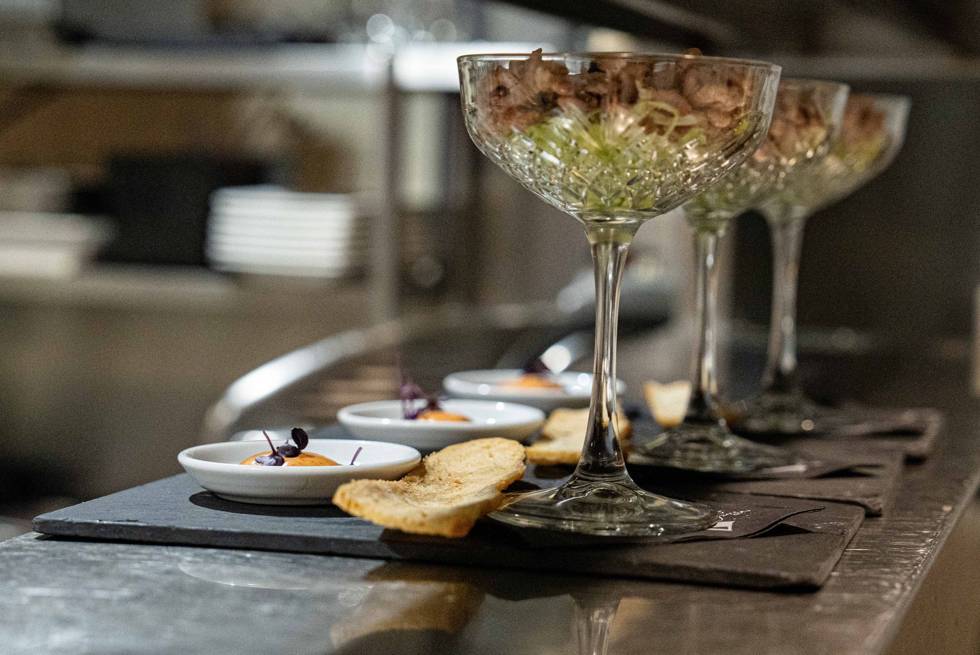 Een rij champagneglazen gevuld met eten op een aanrecht. . Bij Linke Loetje