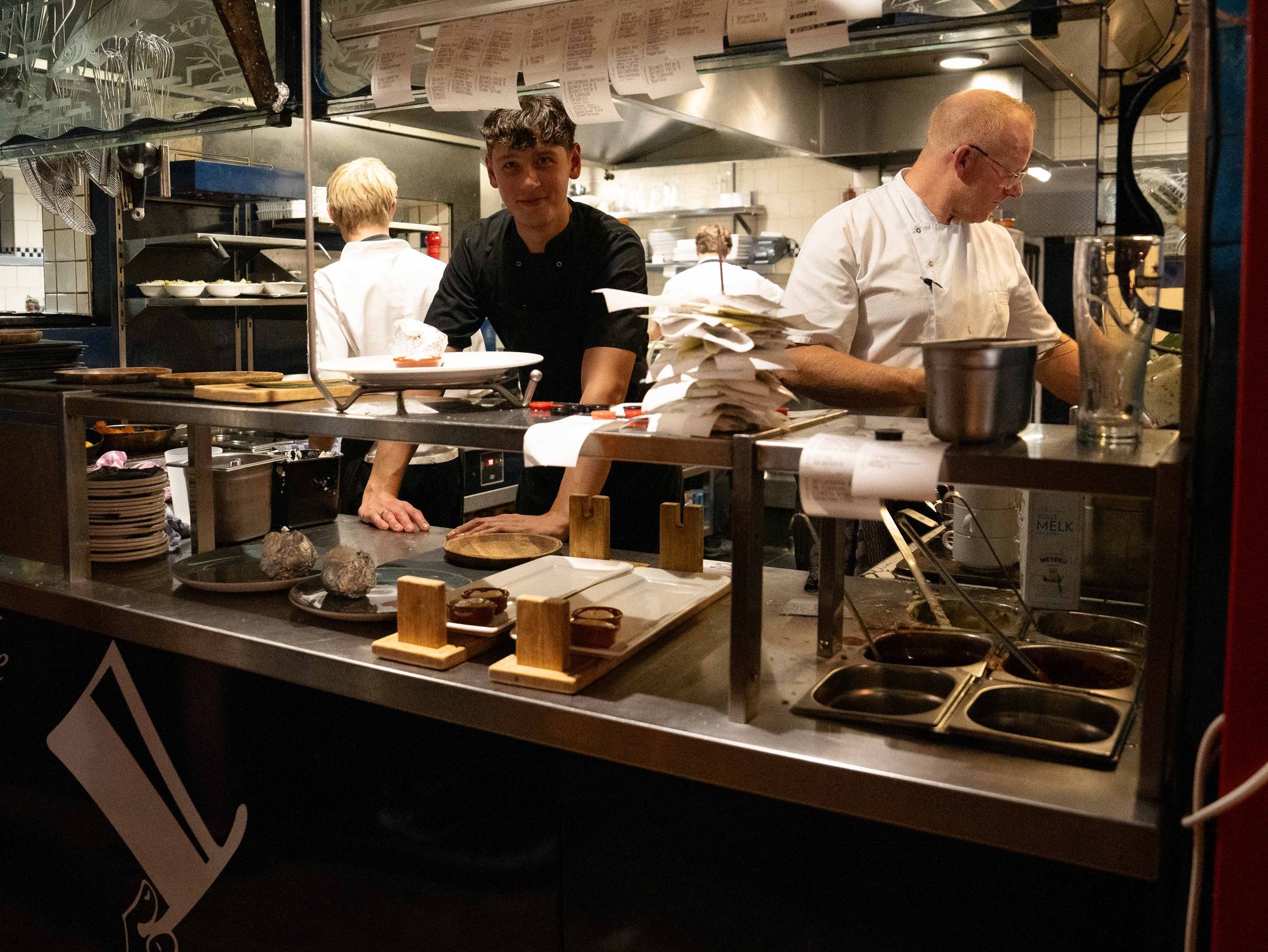 Twee mannen werken in een keuken en bereiden eten. . Bij Linke Loetje