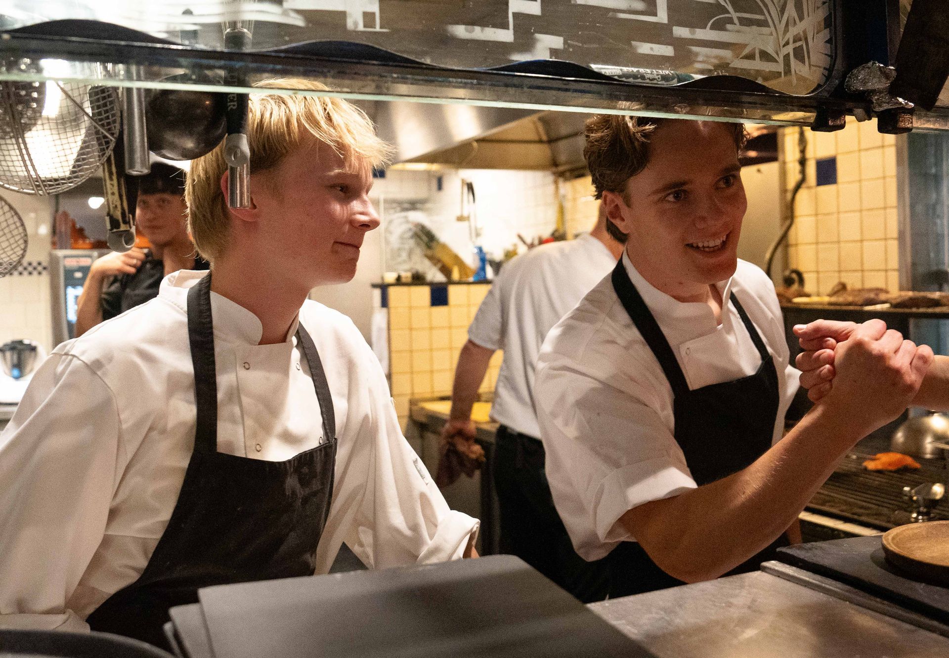 Twee mannen in schorten staan ​​naast elkaar in een keuken