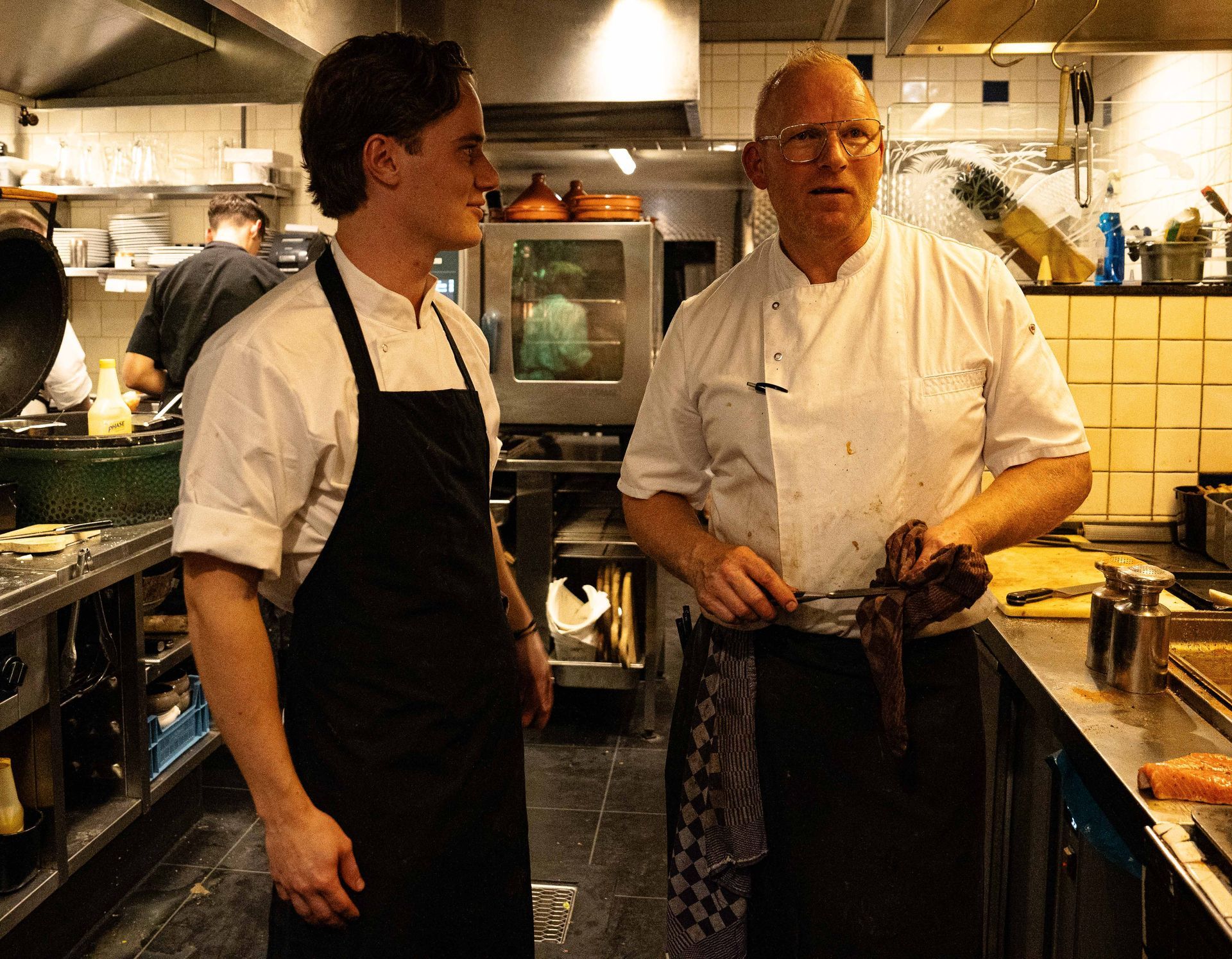 Twee mannen staan ​​in een keuken met elkaar te praten . Bij Linke Loetje