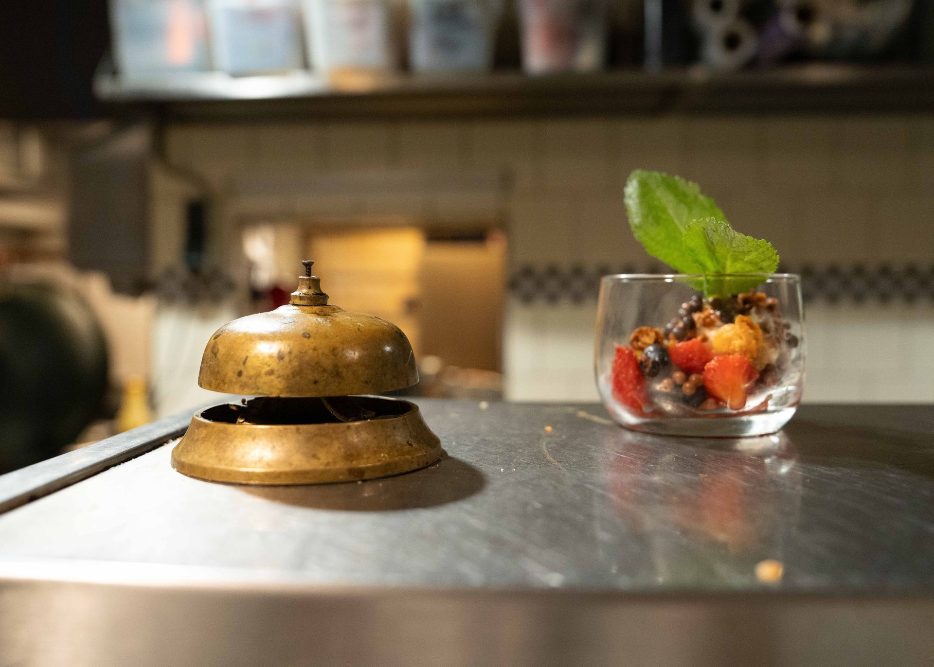 Een bel en een glas fruit staan ​​op een toonbank. . Bij Linke Loetje