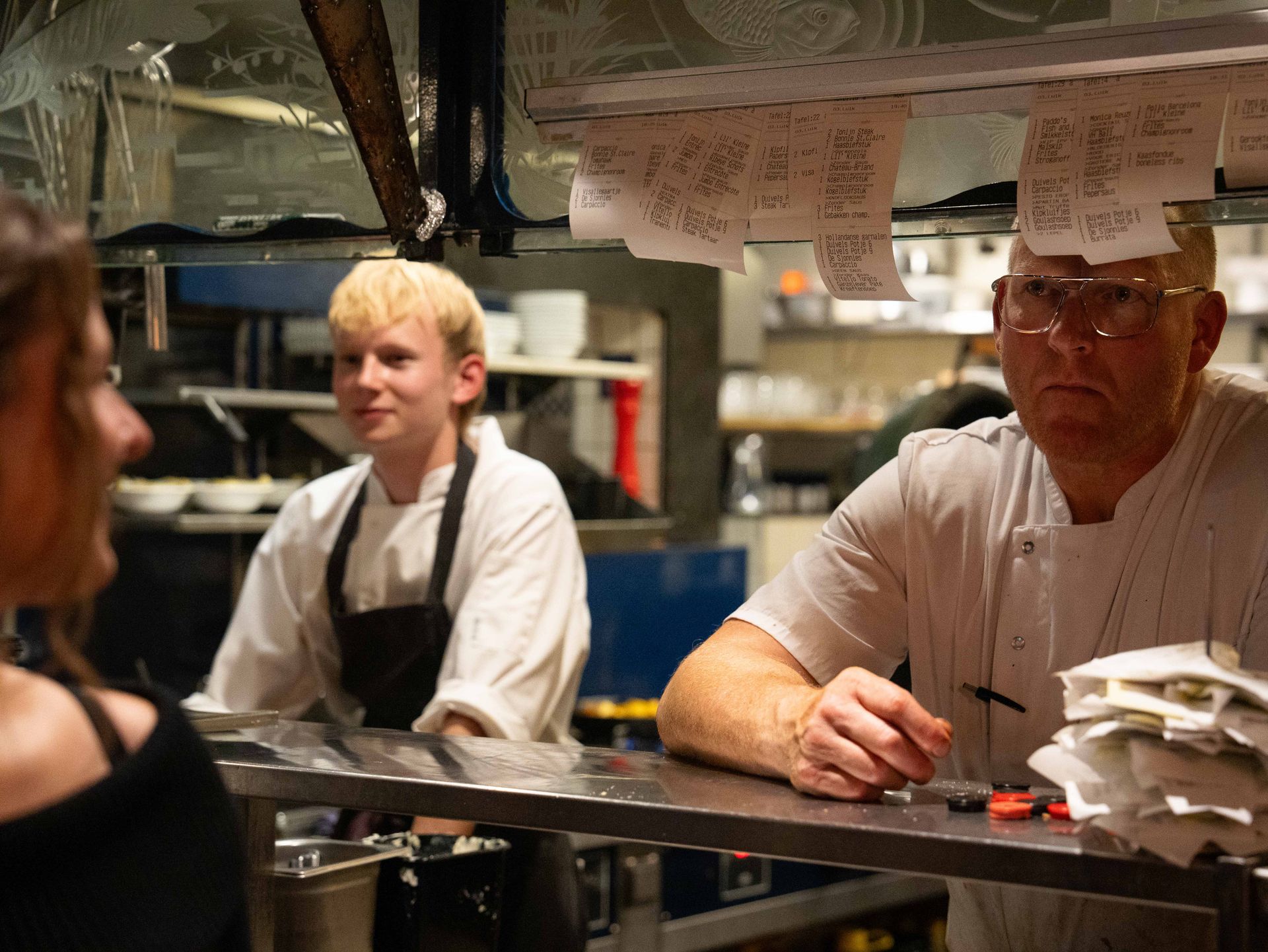 Een man en een jongen staan ​​in een keuken met bonnetjes op hun hoofd geplakt