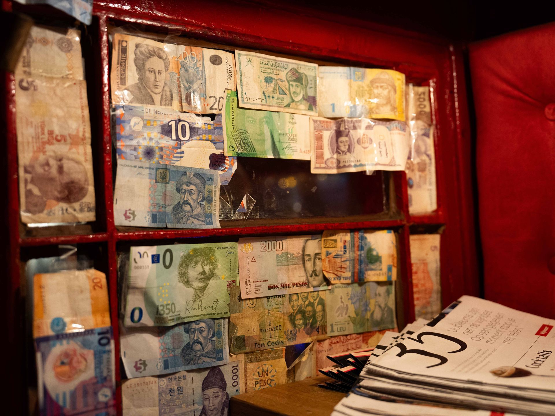 Een stapel kranten ligt voor een plank vol geld