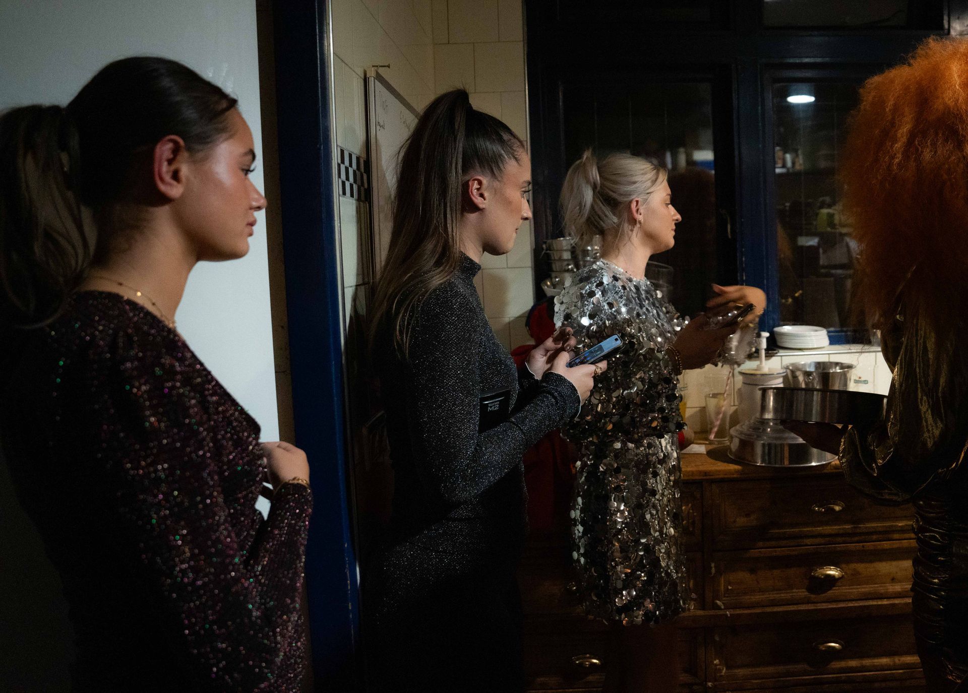Een groep vrouwen staat naast elkaar in een donkere kamer.. Bij Linke Loetje