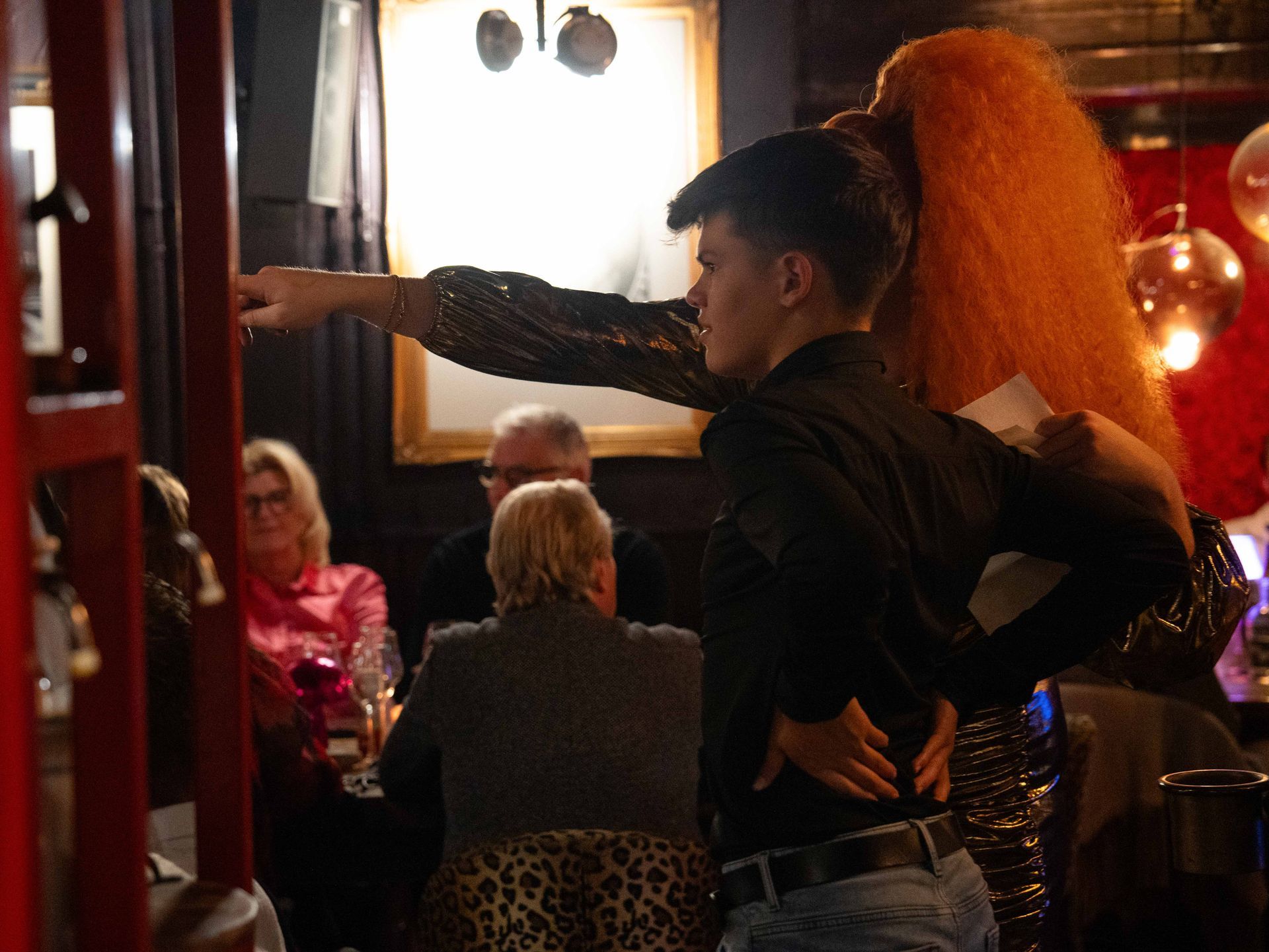Een man en een vrouw dansen voor een groep mensen.. Bij Linke Loetje