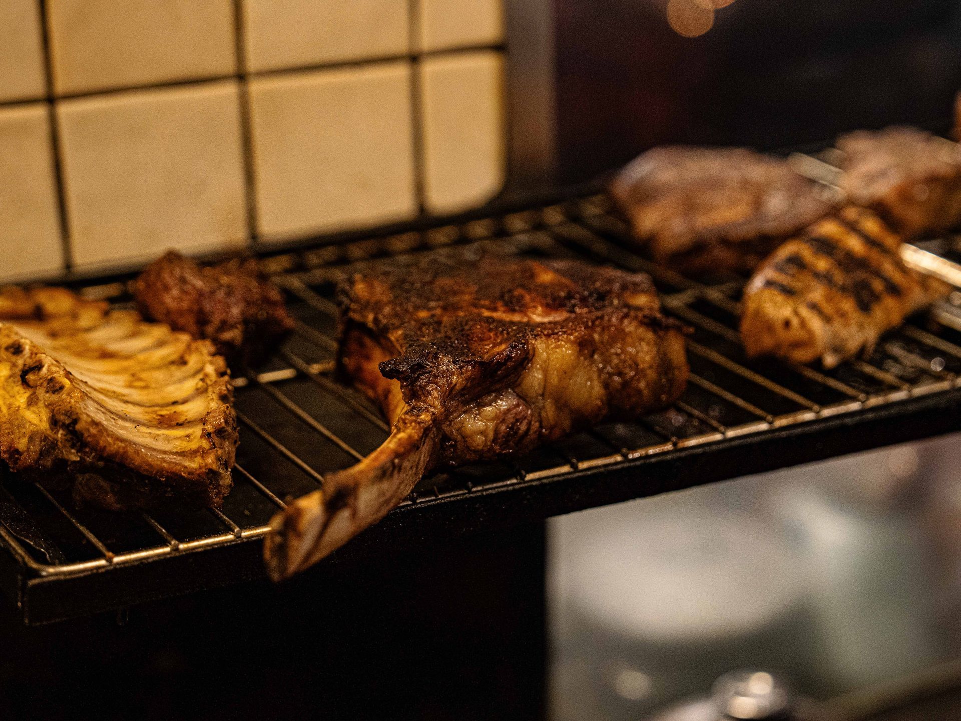 Er ligt een hoop vlees op de grill te garen.