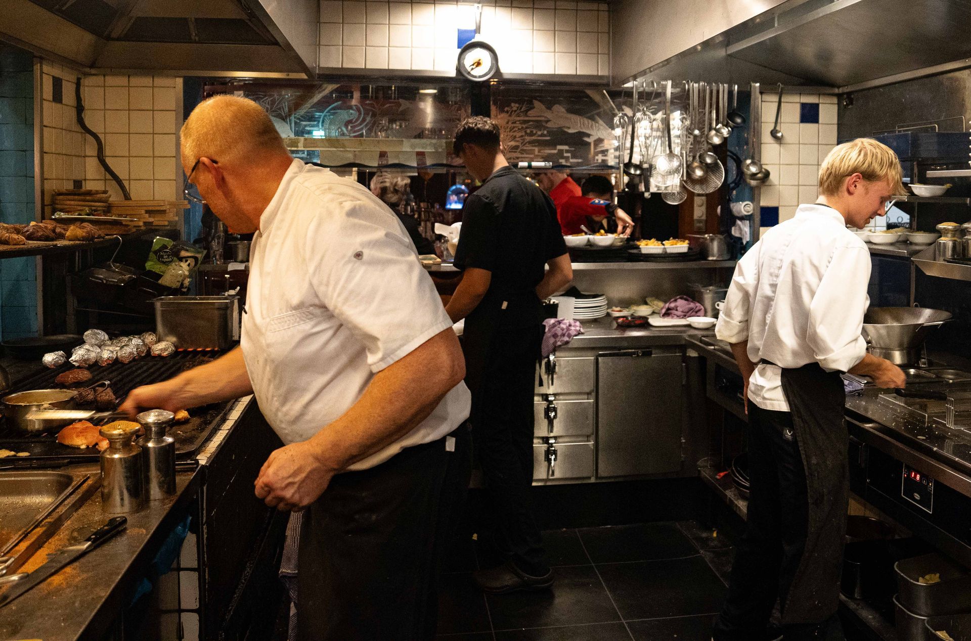 Een groep koks is in een keuken bezig met het bereiden van eten