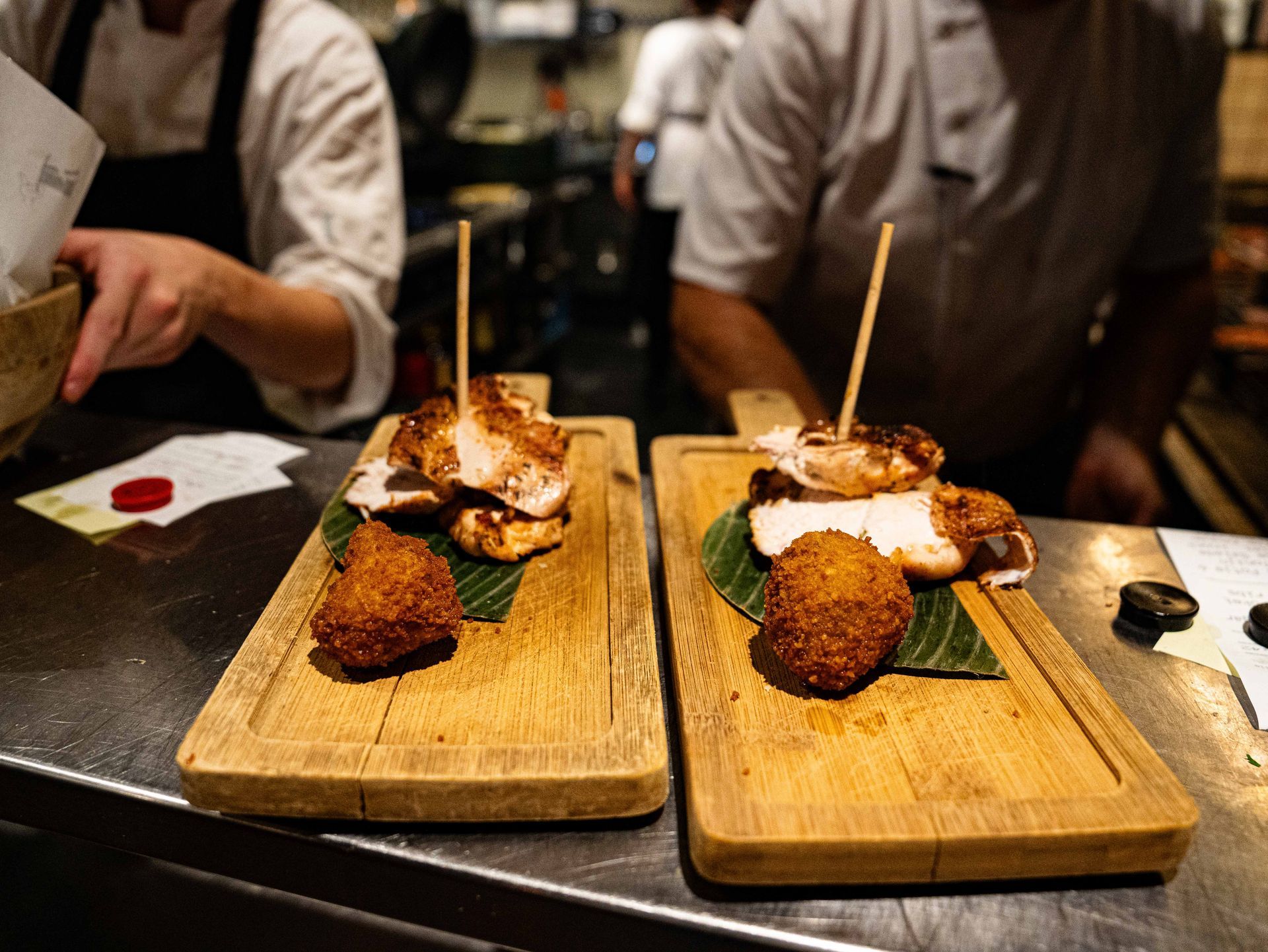 Twee houten snijplanken met eten erop op een aanrecht.