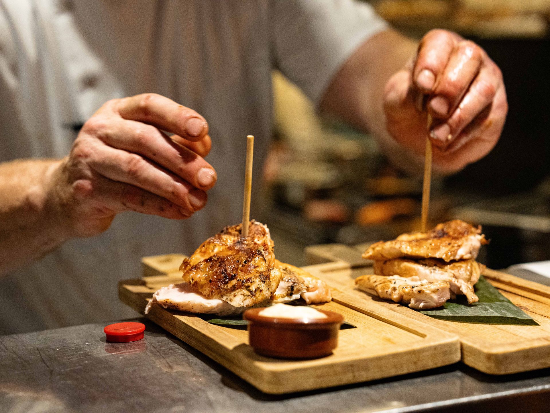 Een chef-kok bereidt eten op een houten snijplank.