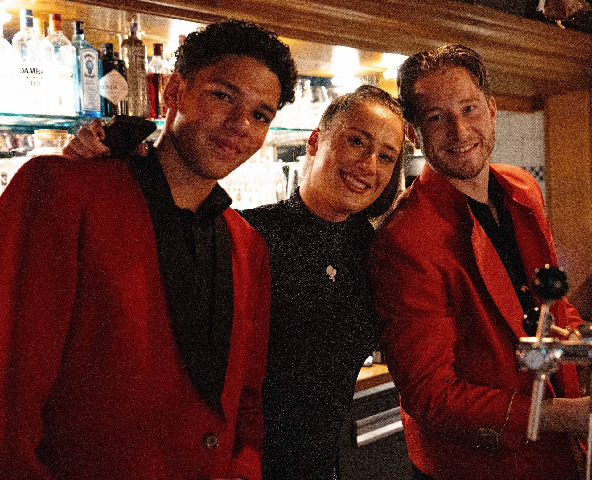 Drie mensen in rode jassen poseren voor een foto