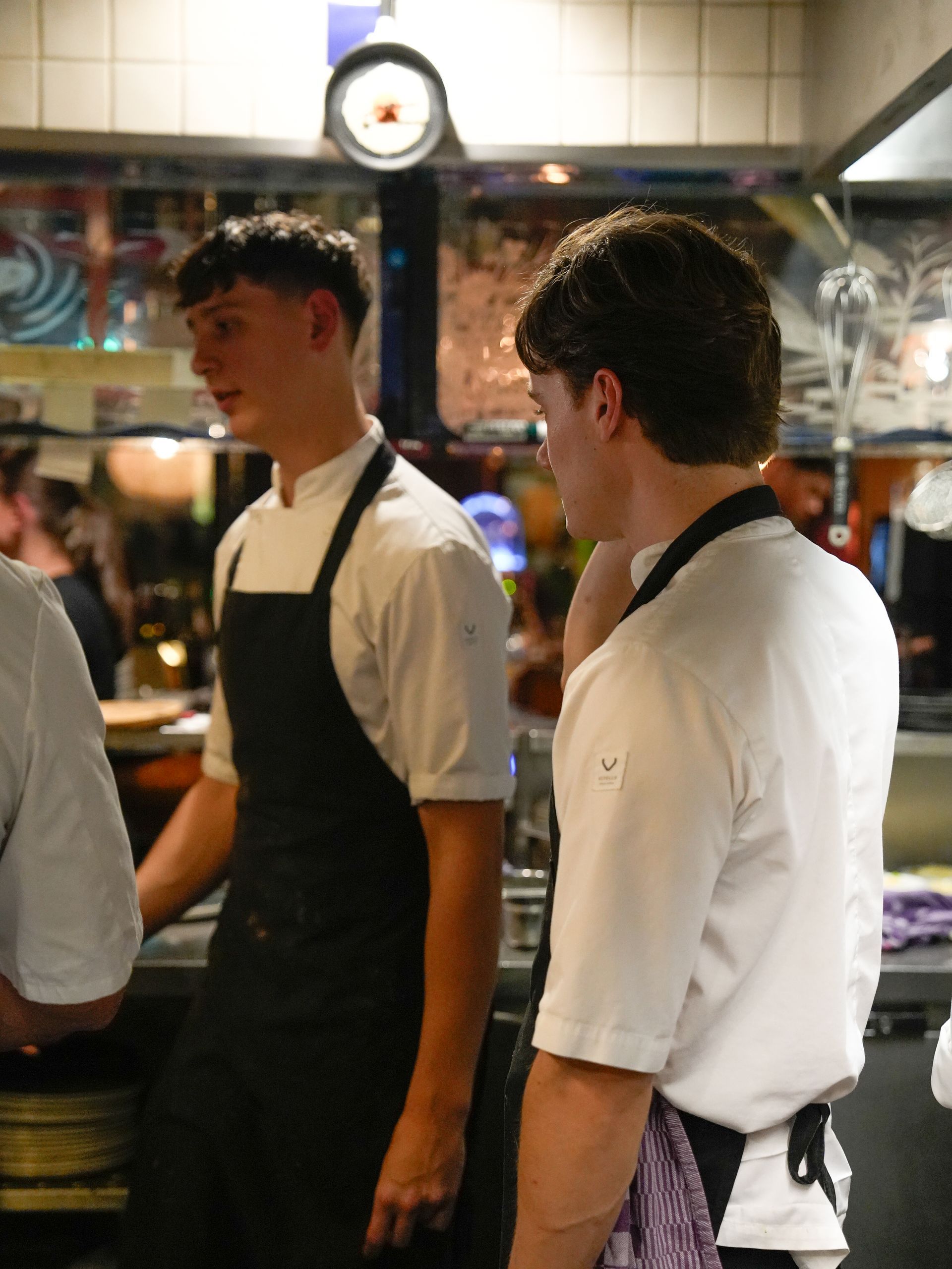 Twee mannen in schorten staan ​​in een keuken. Bij Linke Loetje