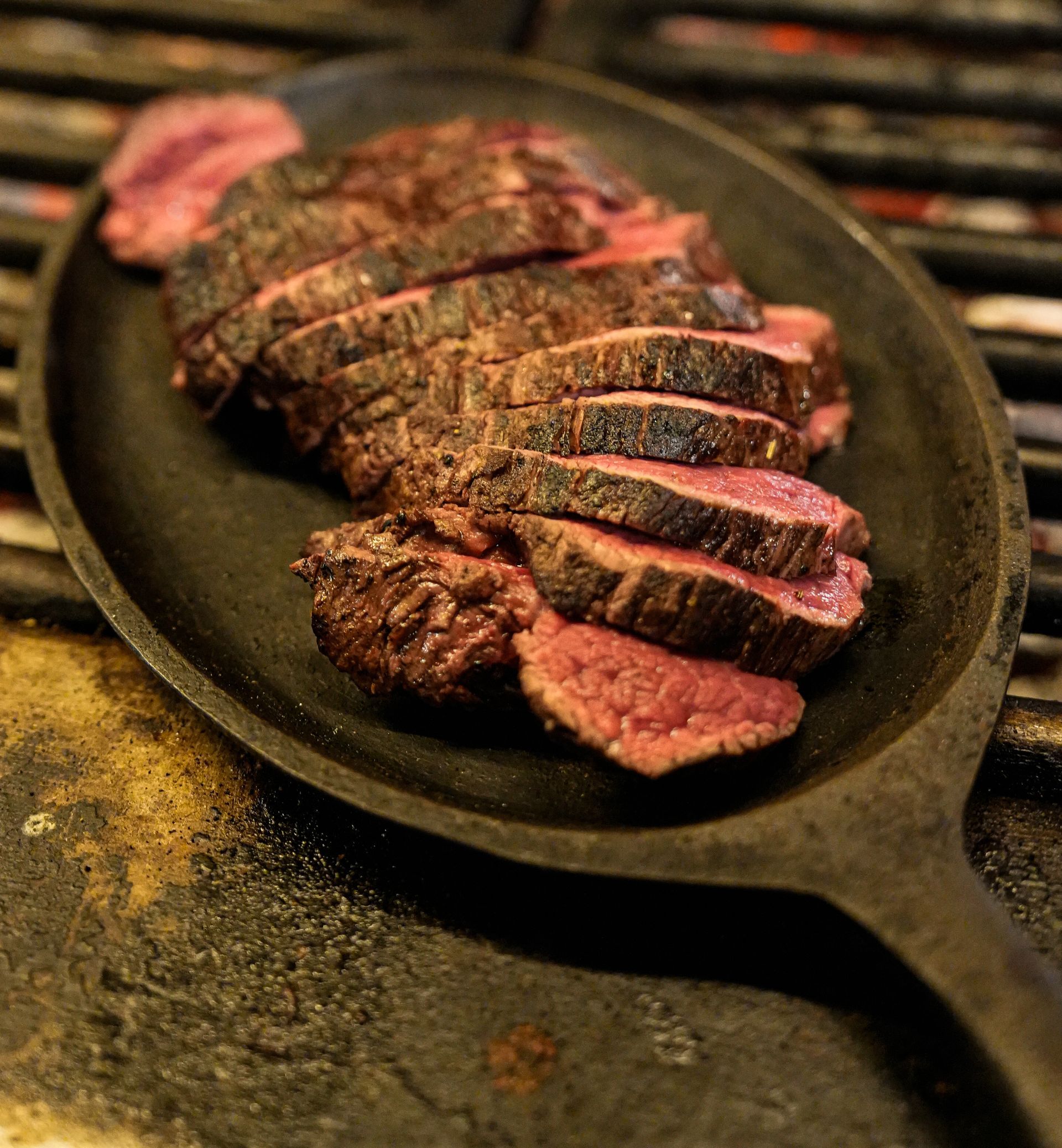 Een koekenpan gevuld met plakjes biefstuk op een grill. Bij Linke Loetje