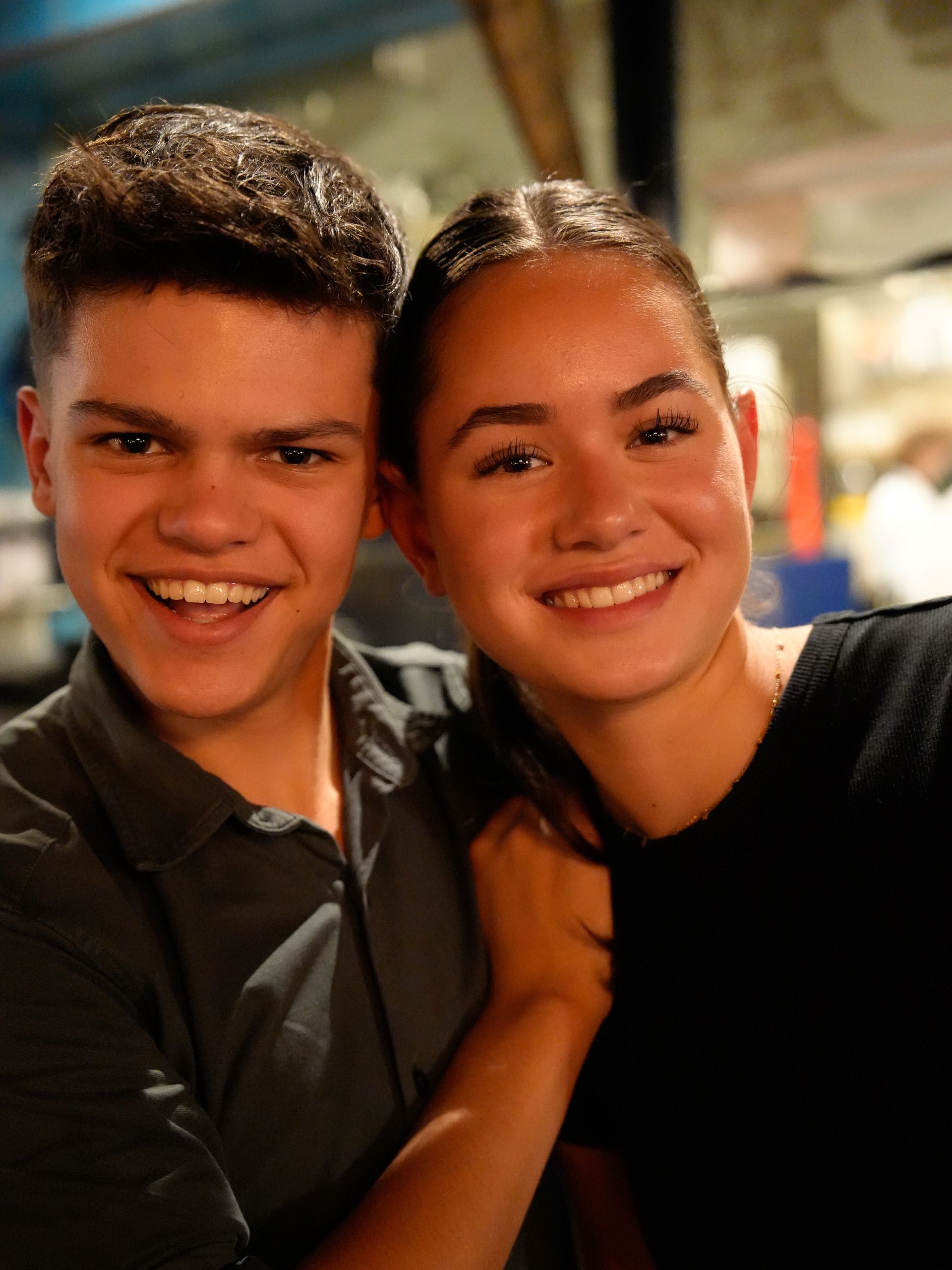 Een jongen en een meisje poseren voor een foto en lachen naar de camera. . Bij Linke Loetje