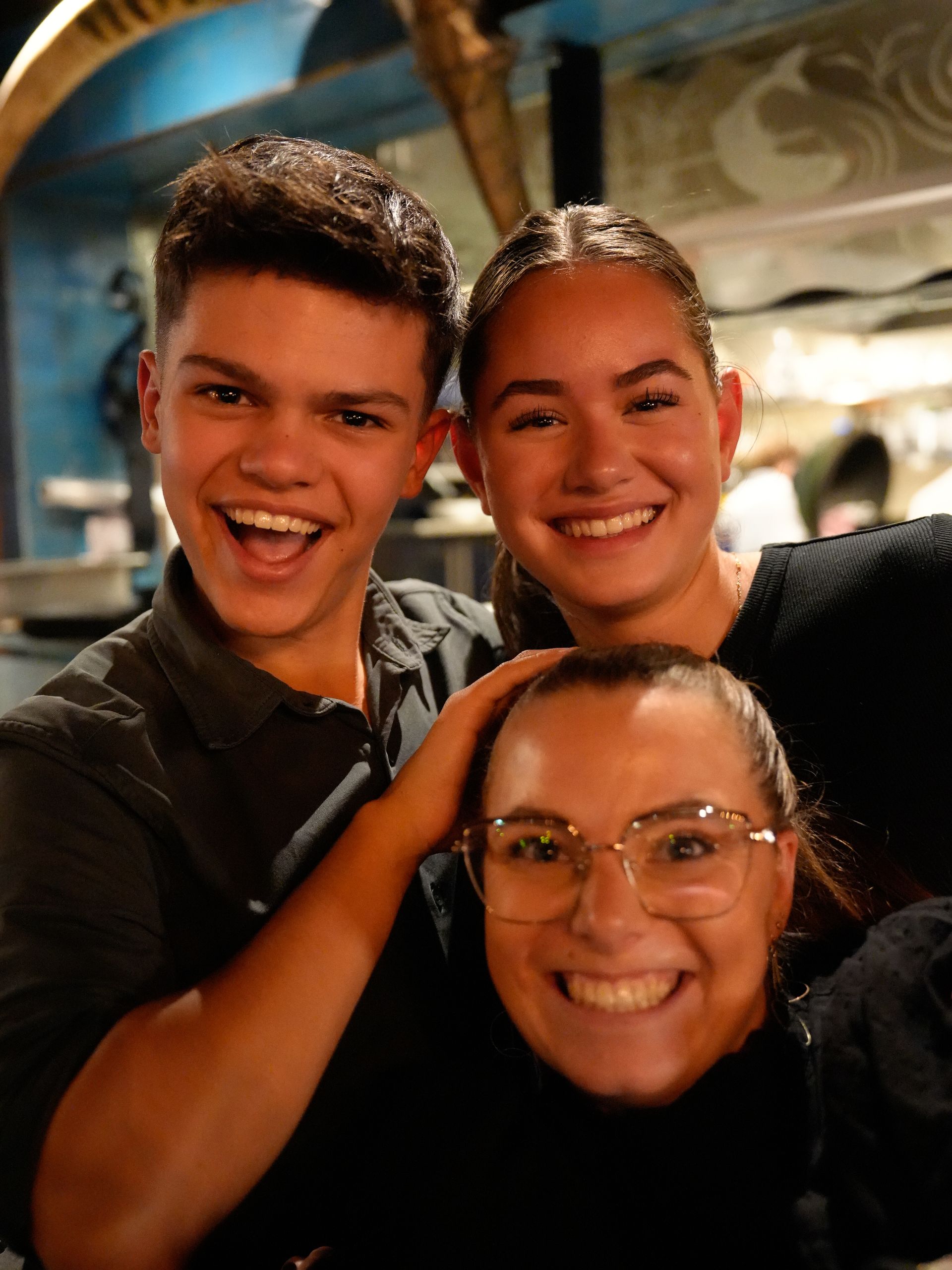 Een jongen en twee meisjes poseren voor een foto en lachen