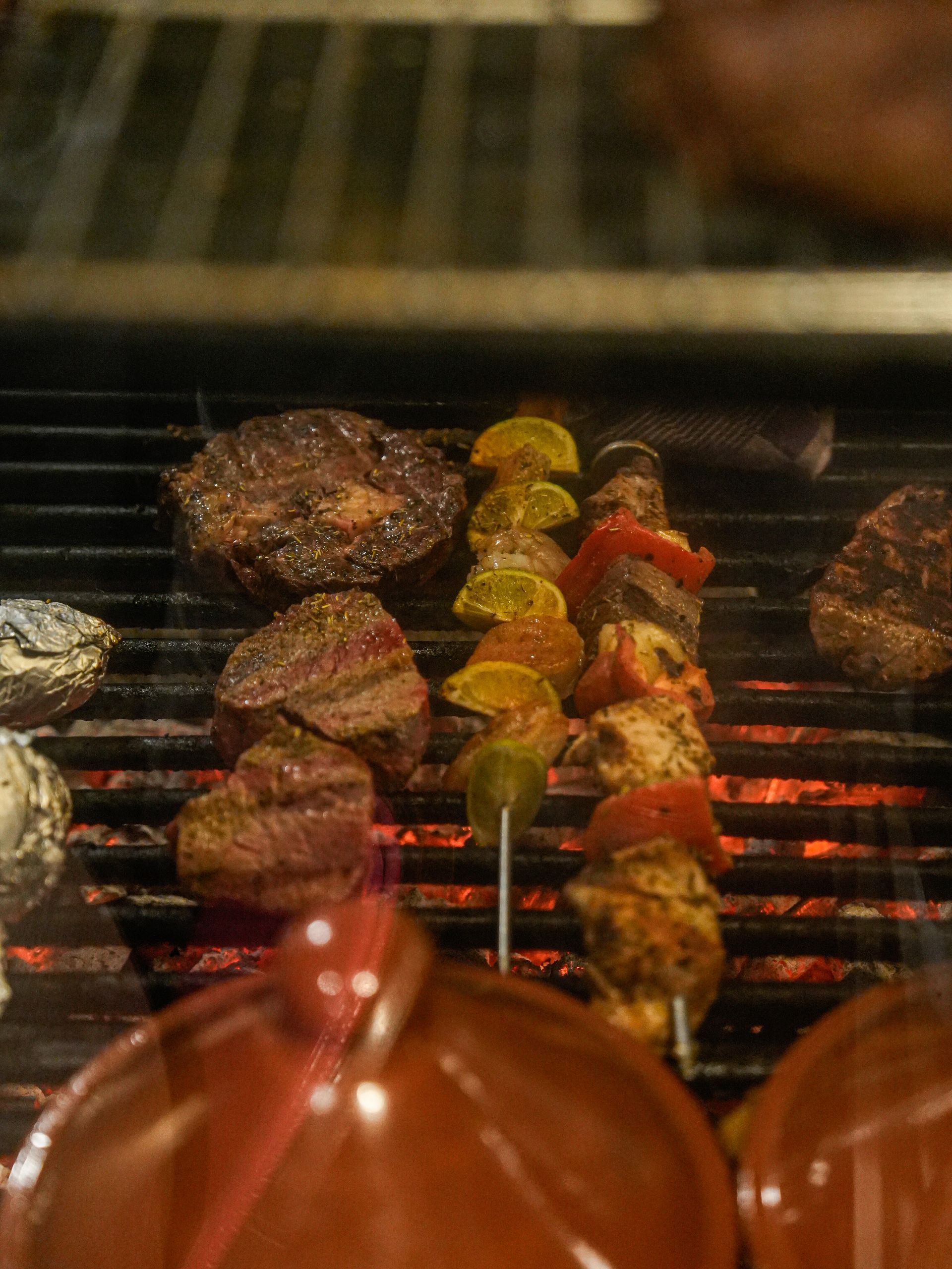 Op een grill worden verschillende soorten vlees en groenten bereid.. Bij Linke Loetje