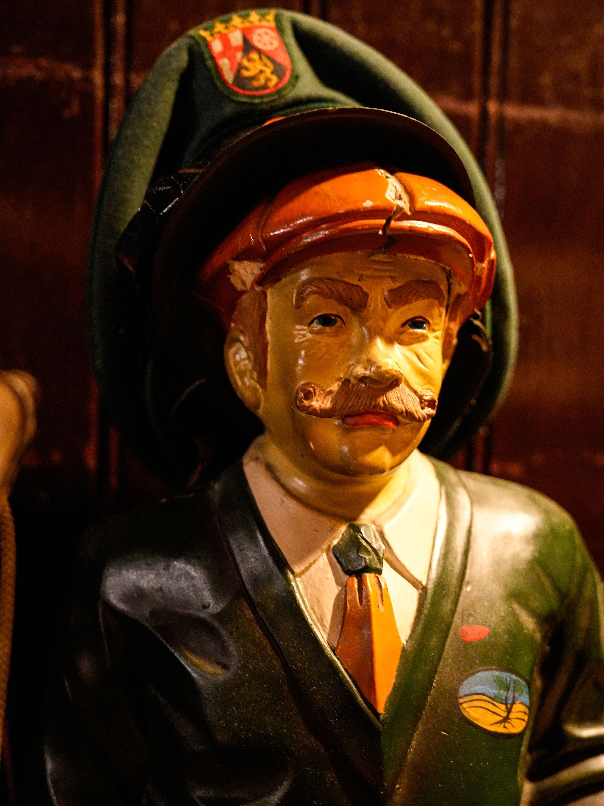 Een standbeeld van een man met een hoed en stropdas. Bij Linke Loetje