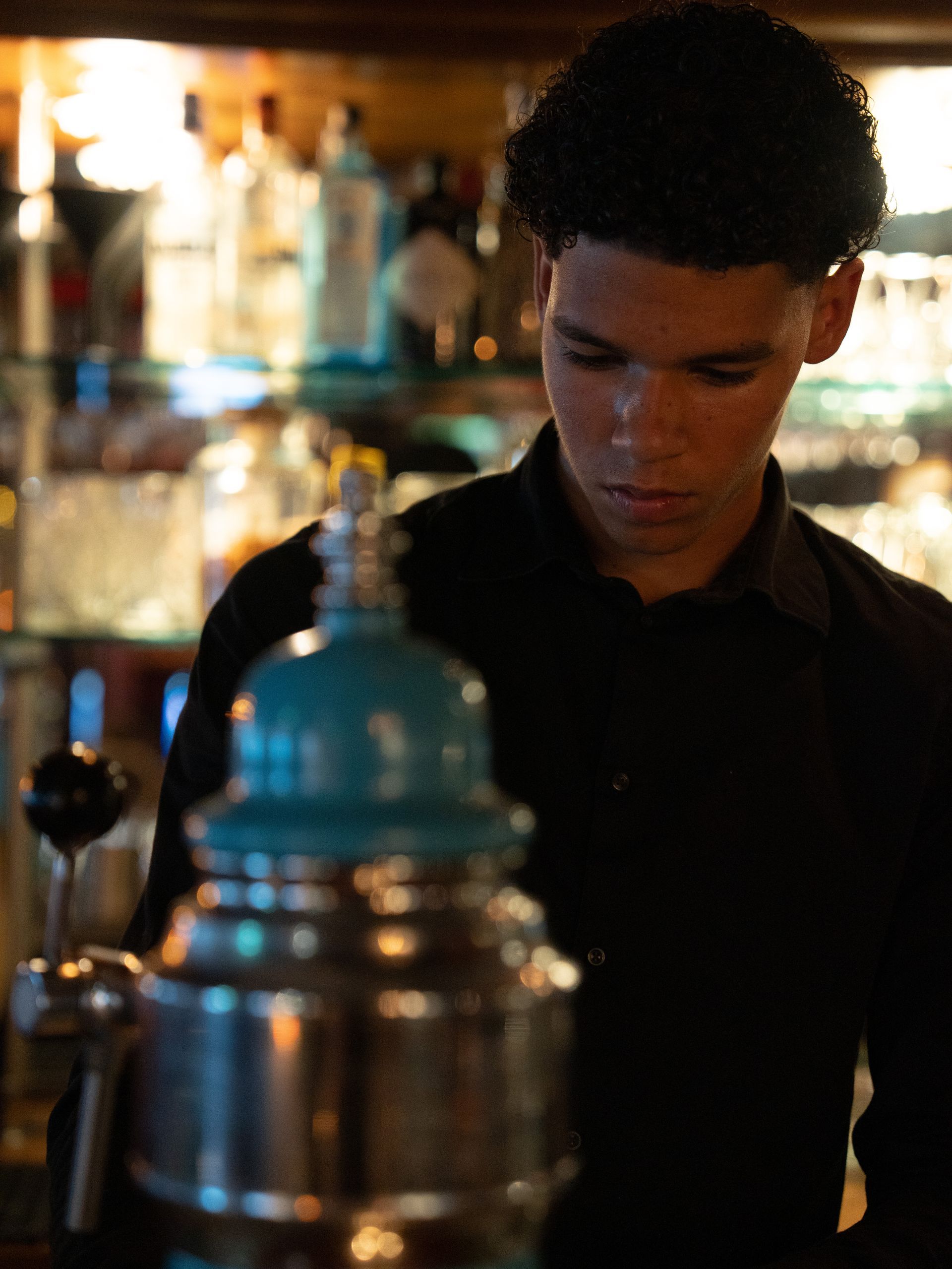 Een man in een zwart shirt staat voor een grote container met een blauwe . Bij Linke Loetjebovenkant.