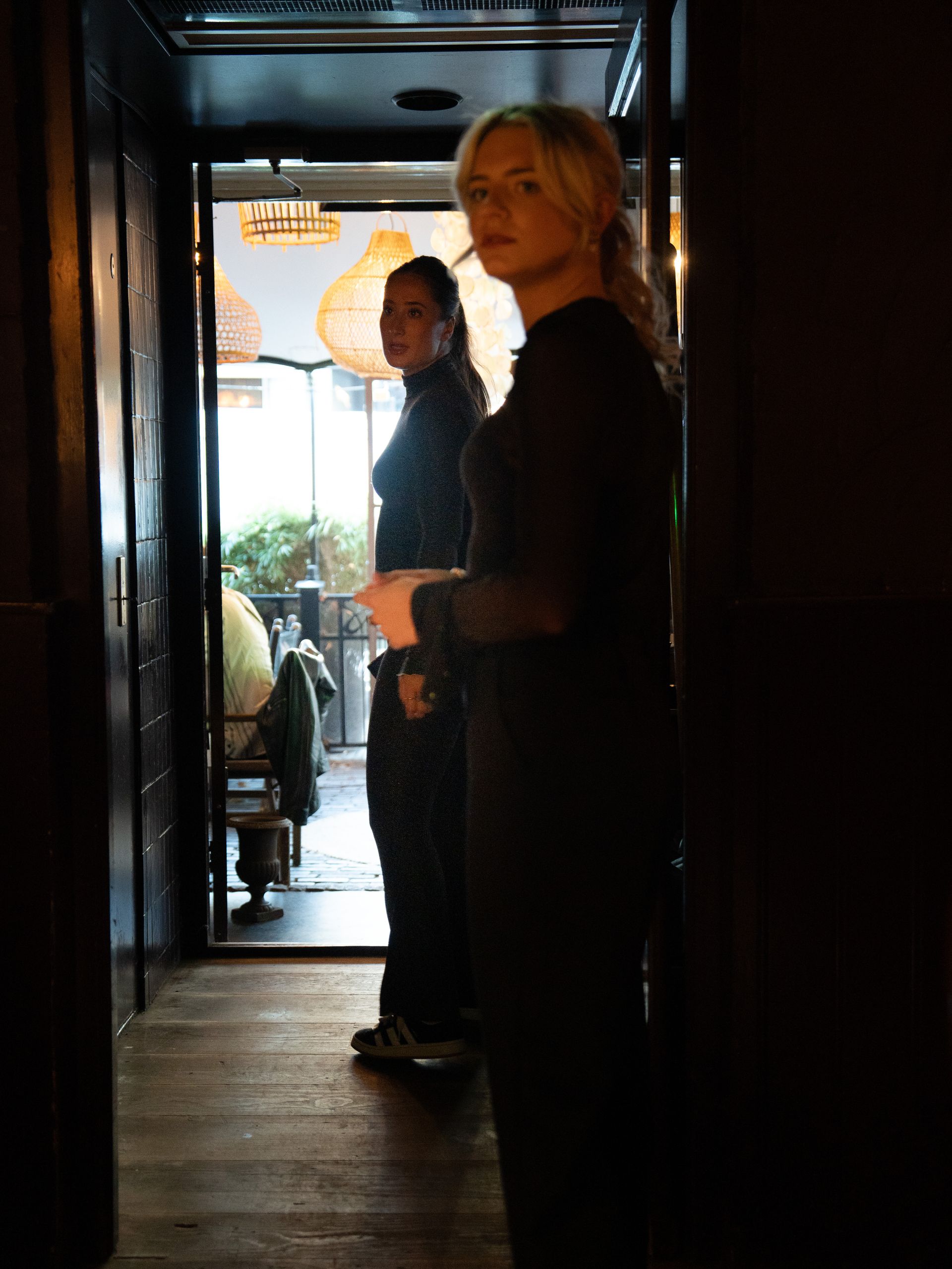 Twee vrouwen staan ​​in een gang in een donkere kamer.. Bij Linke Loetje