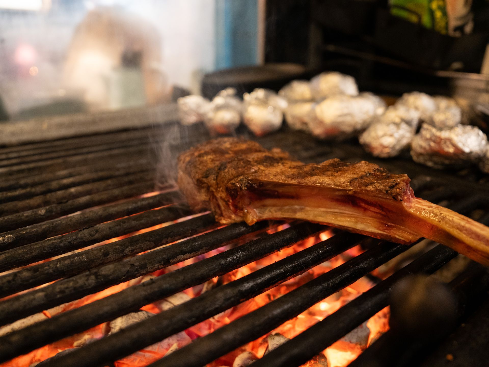 Een stuk vlees wordt op een grill bereid.. Bij Linke Loetje