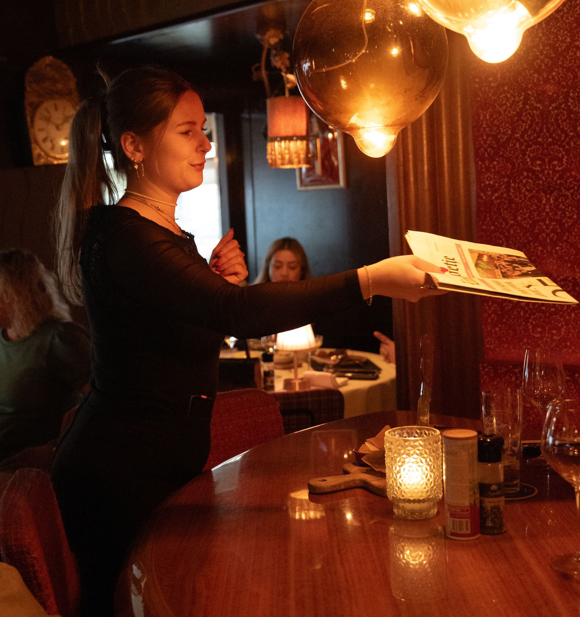 Een vrouw die een dienblad met eten serveert in een restaurant. Bij Linke Loetje