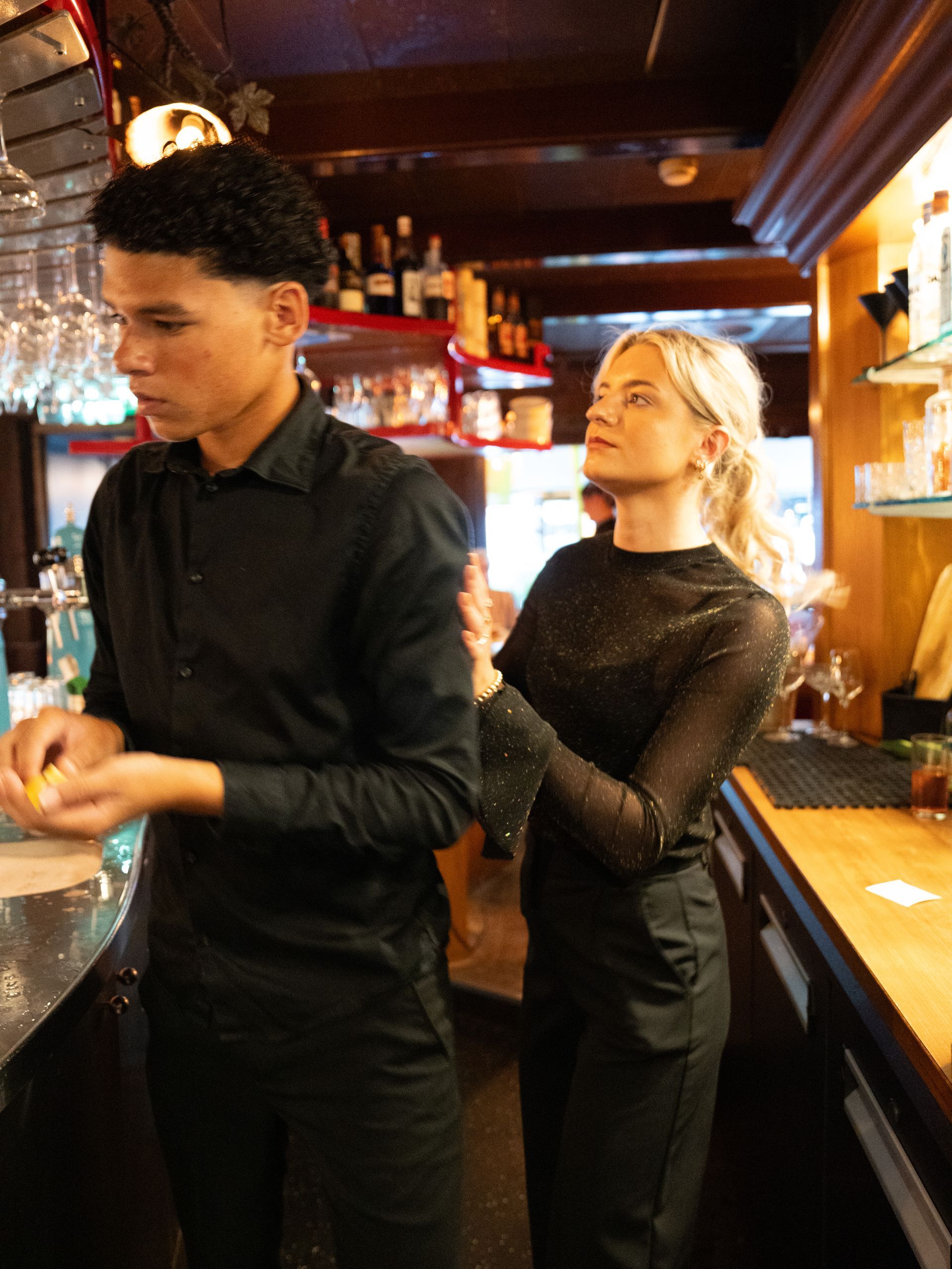 Een man en een vrouw staan ​​naast elkaar in een bar.. Bij Linke Loetje