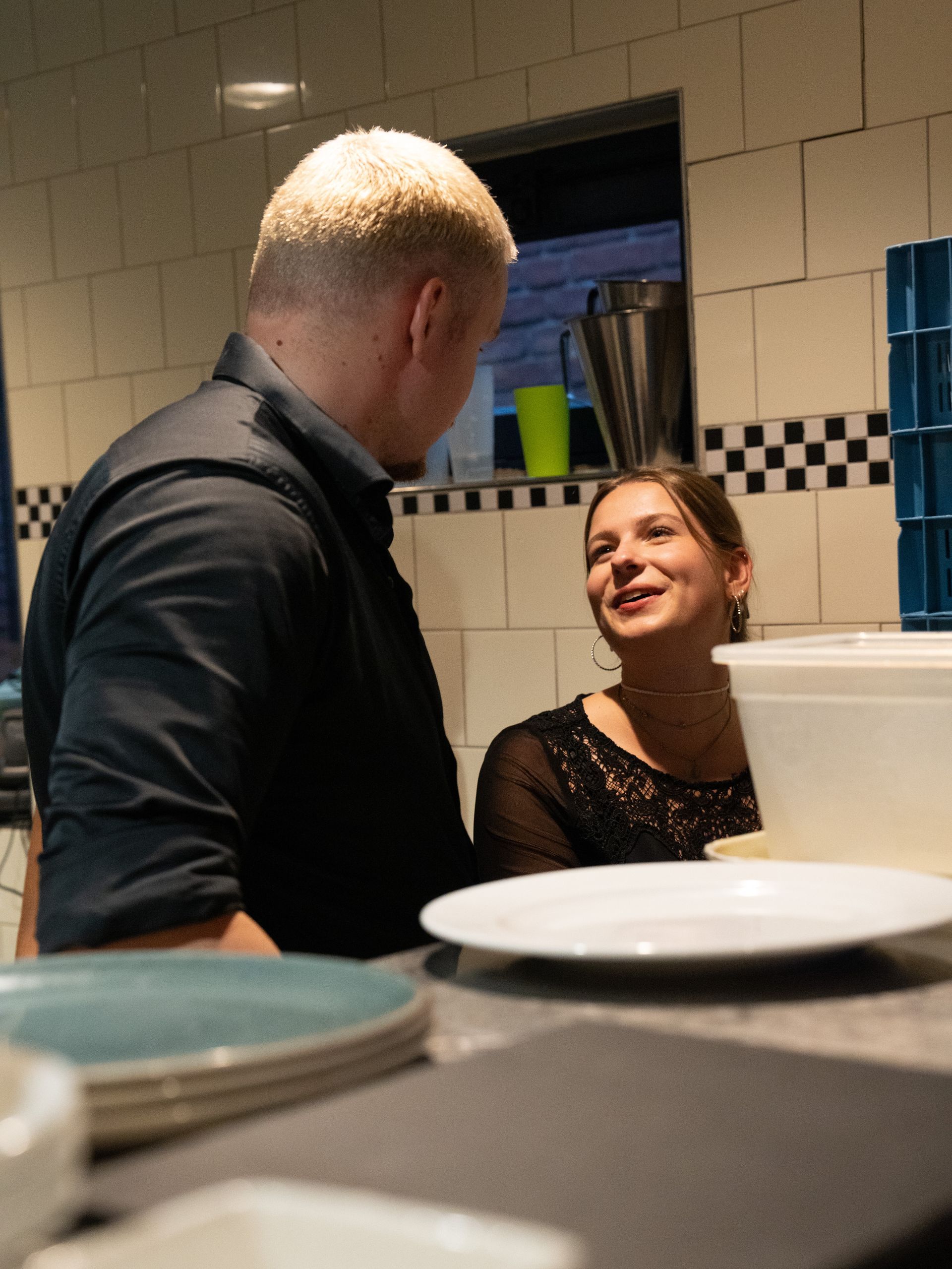 Een man en een vrouw zitten aan een tafel met borden erop. Bij Linke Loetje