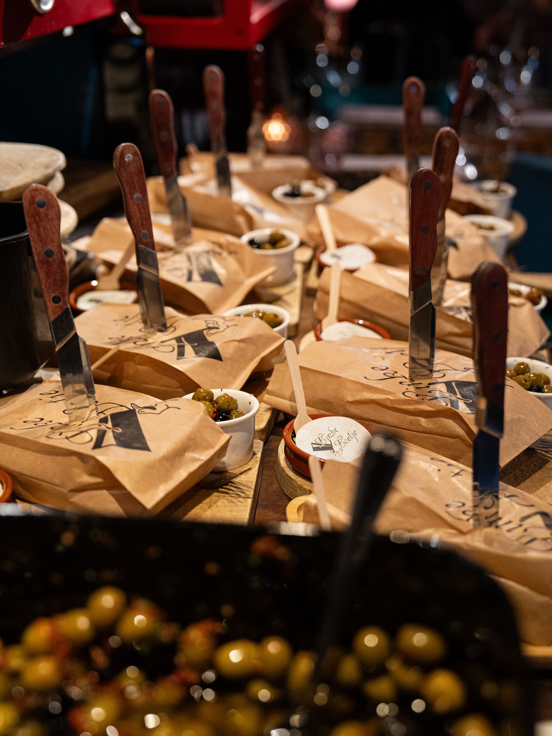 Een tafel met veel eten en messen erop. Bij Linke Loetje