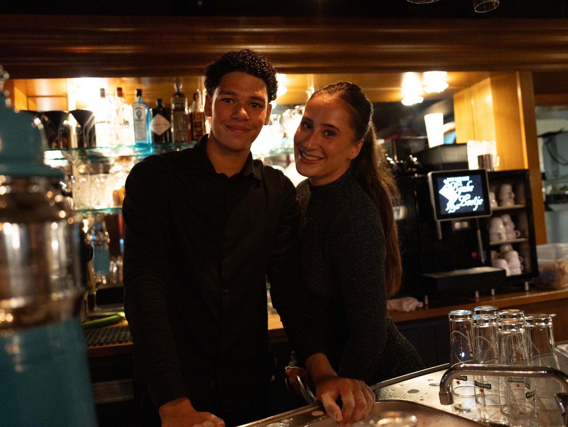 Een man en een vrouw staan ​​naast elkaar in een bar.. Bij Linke Loetje
