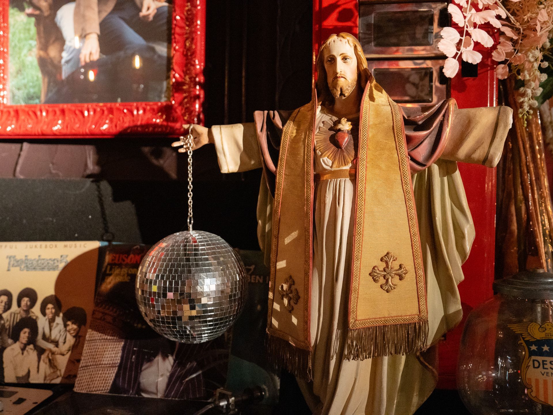 Een beeld van Jezus naast een discobal. Bij Linke Loetje