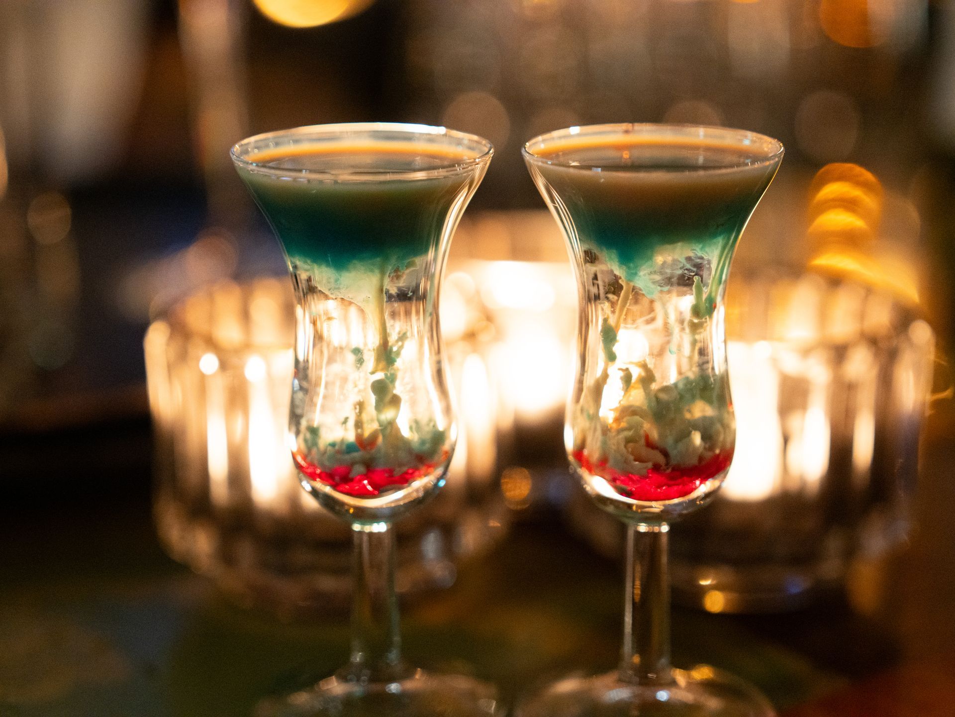 Op tafel staan ​​twee shotglaasjes gevuld met een kleurrijk drankje.. Bij Linke Loetje