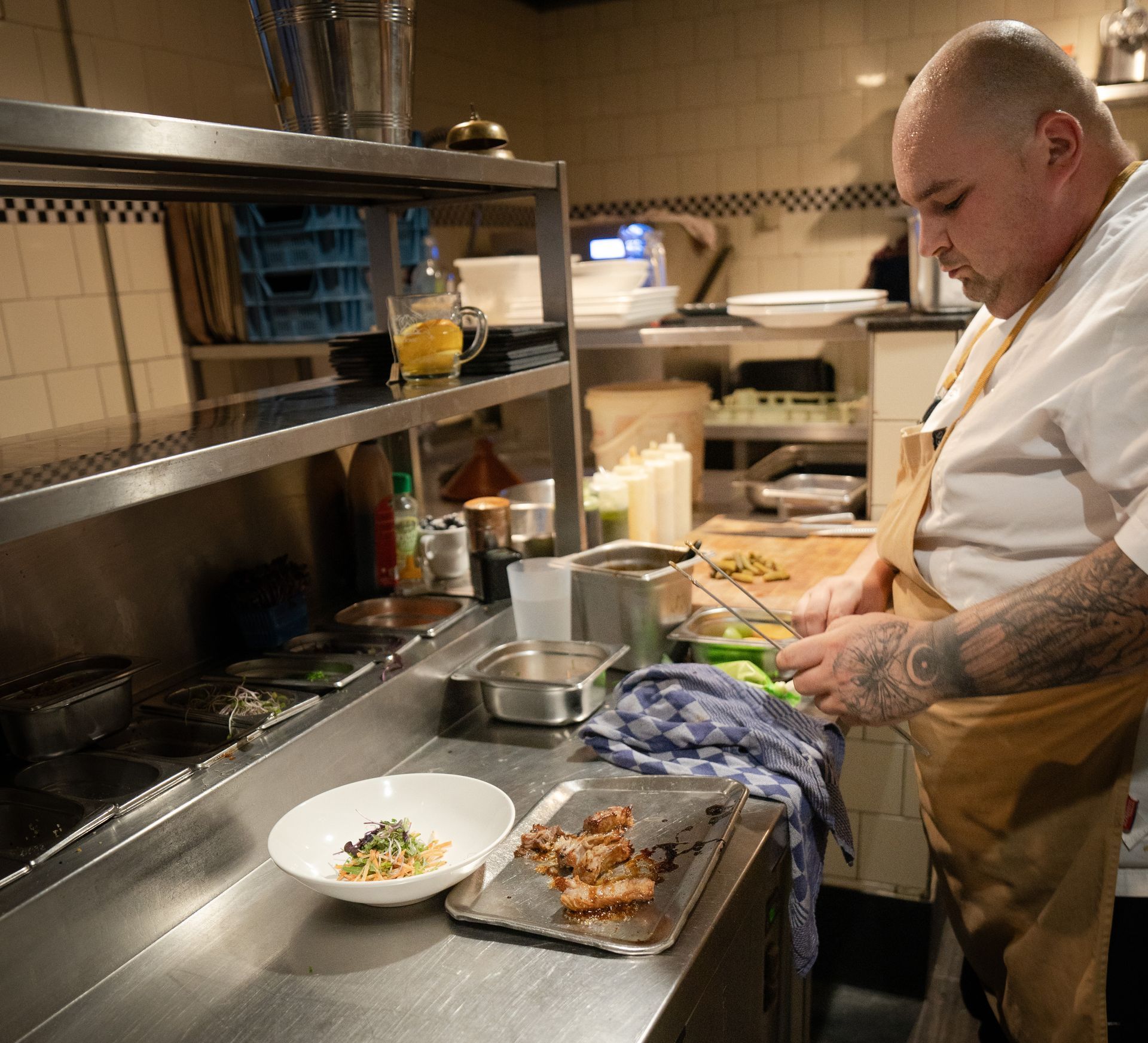 Een man staat in de keuken en bereidt eten.. Bij Linke Loetje