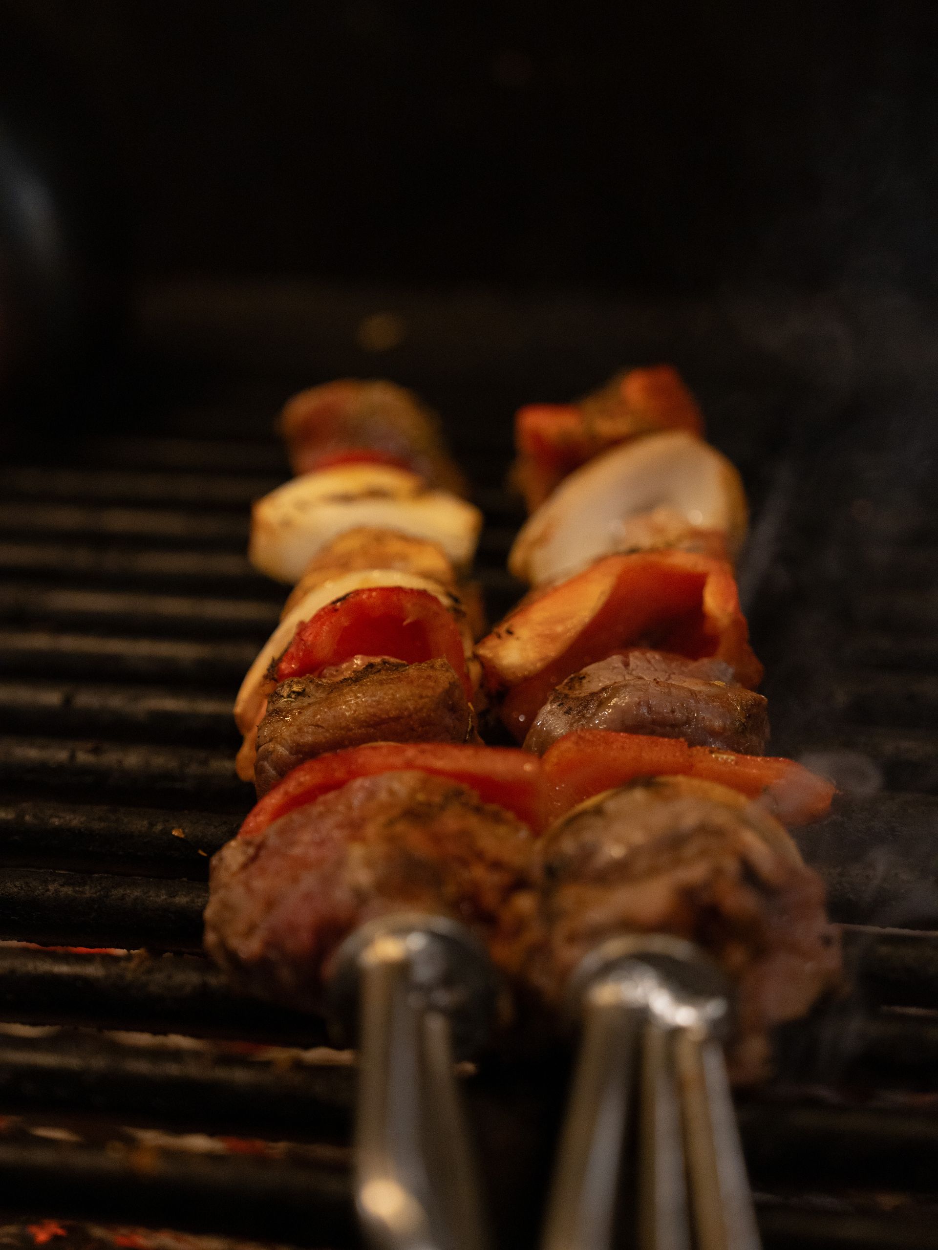 Een close-up van een grill met vlees en groenten erop.. Bij Linke Loetje