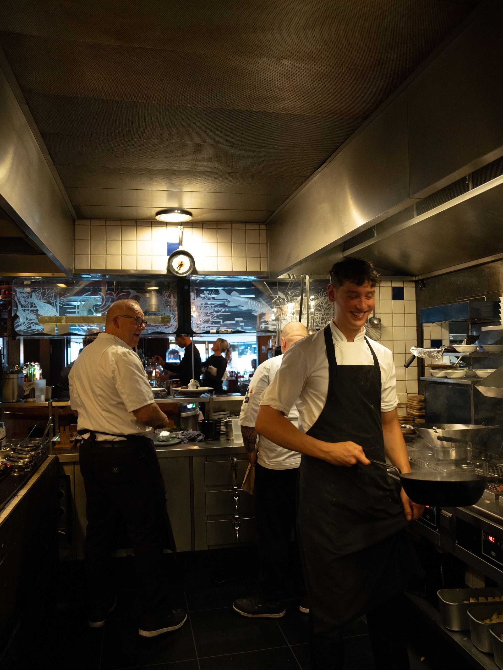 Een groep mannen staat in een keuken eten te bereiden.. Bij Linke Loetje