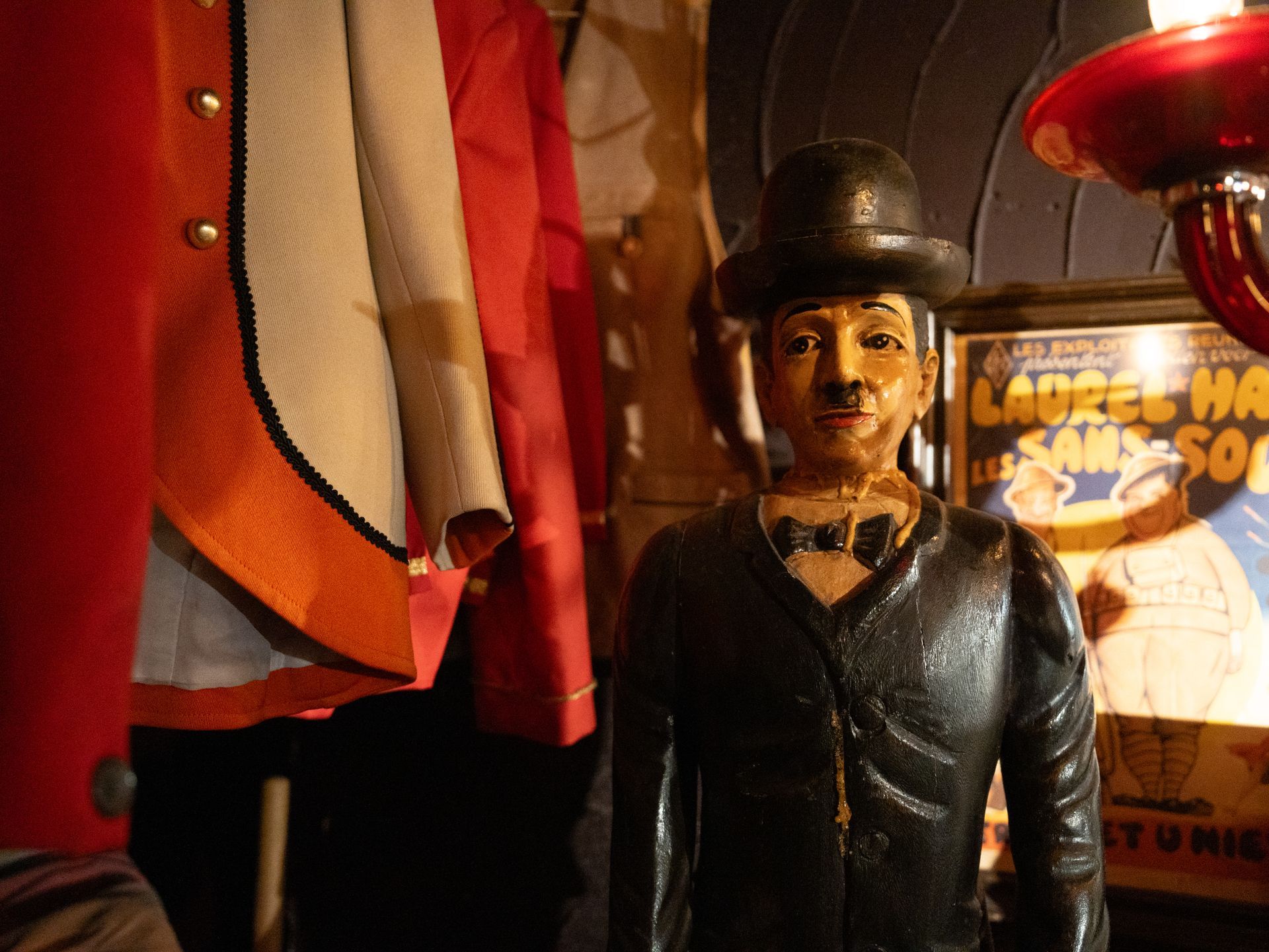 Een standbeeld van een man met een hoed en vlinderdas. Bij Linke Loetje