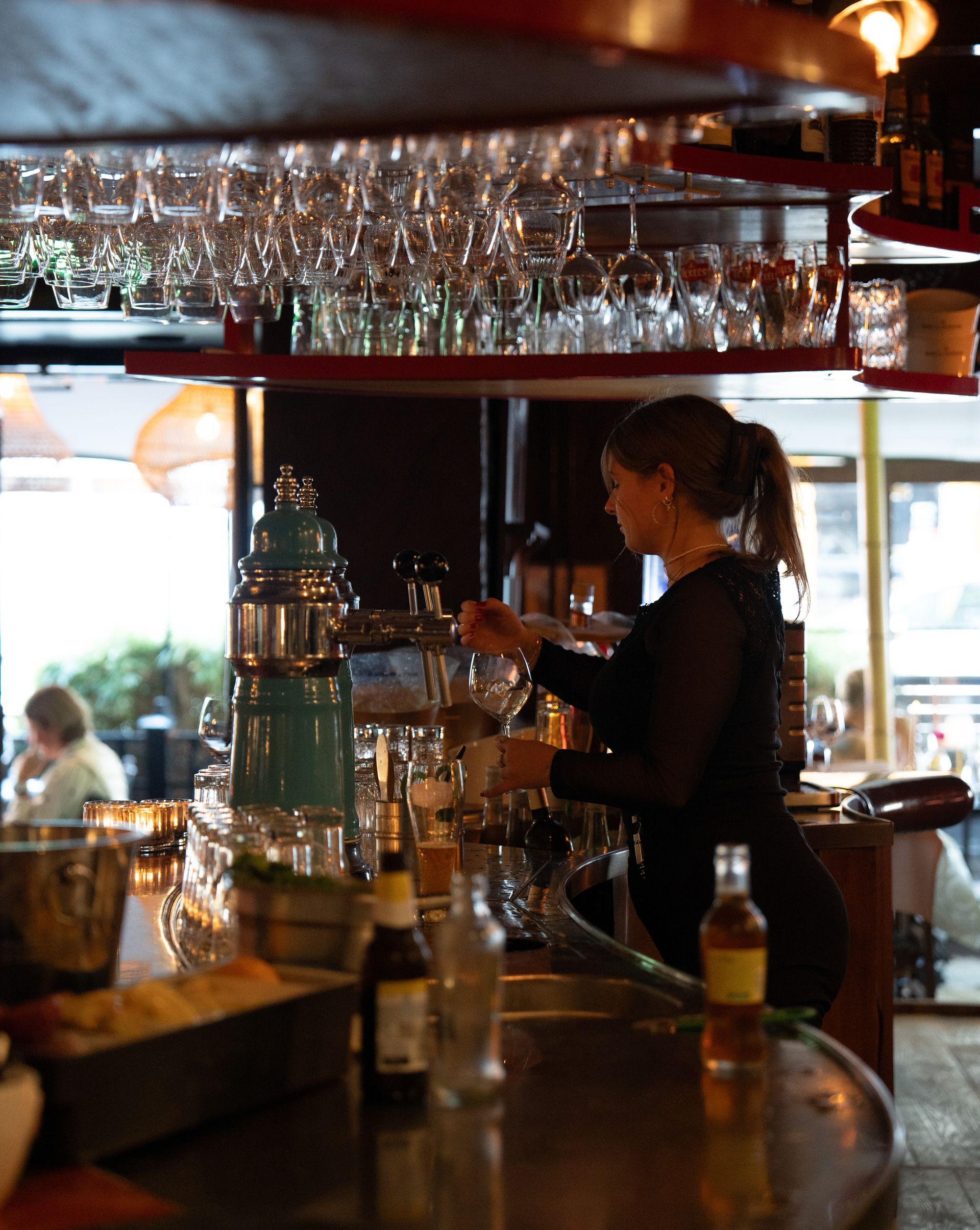 Een barman schenkt een drankje in een glas. Bij Linke Loetje