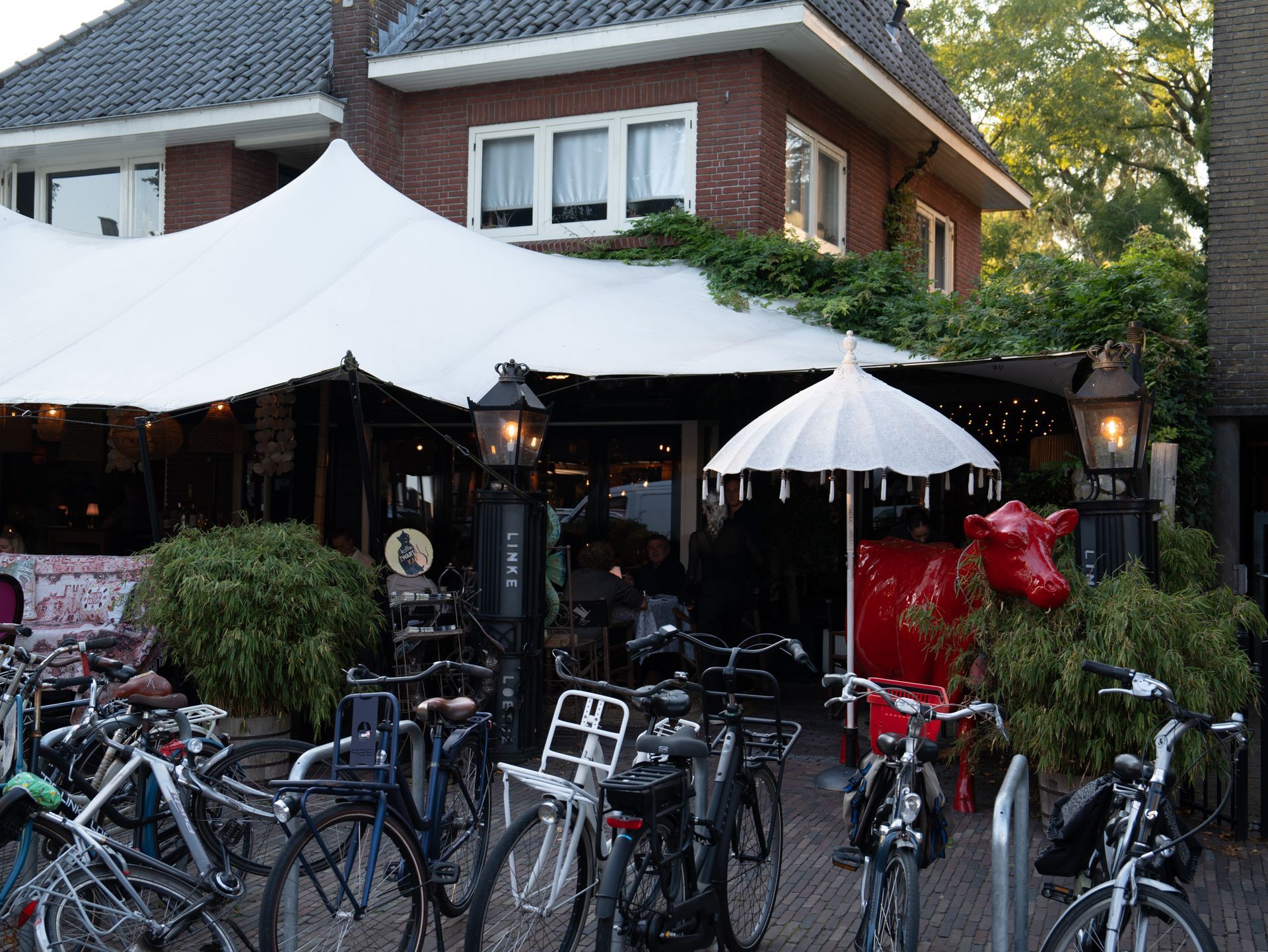 Een aantal fietsen staan ​​geparkeerd voor een restaurant. Bij Linke Loetje